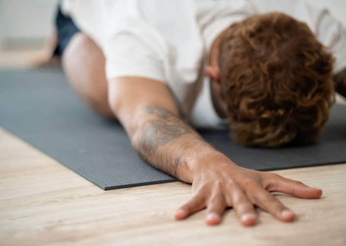 Man practices Child's Pose, yoga for anxiety