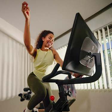 Peloton member smiling riding Peloton Bike