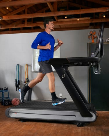 Male running on a Peloton Tread Plus. Female running on Peloton Tread.