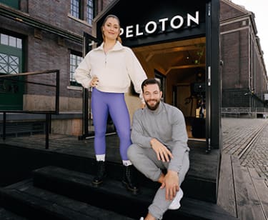 Two trainers standing outside of Peloton Tiny House