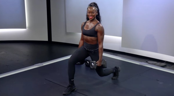 Tunde Oyeneyin lunging forward with dumbbells