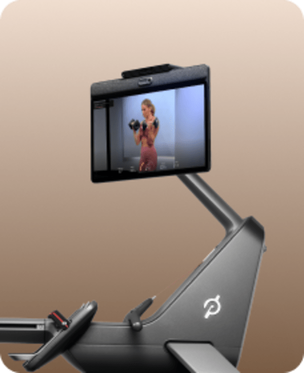 Close-up of a Peloton Row's front base and swivel screen displaying a strength class featuring an instructor with dumbbells.