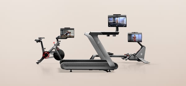 Peloton Bike+, Tread+, and Row+ machines arranged against a neutral background, each displaying a workout class on its screen.