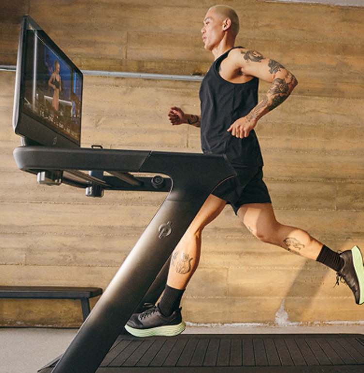 A man running on a Peloton Tread.