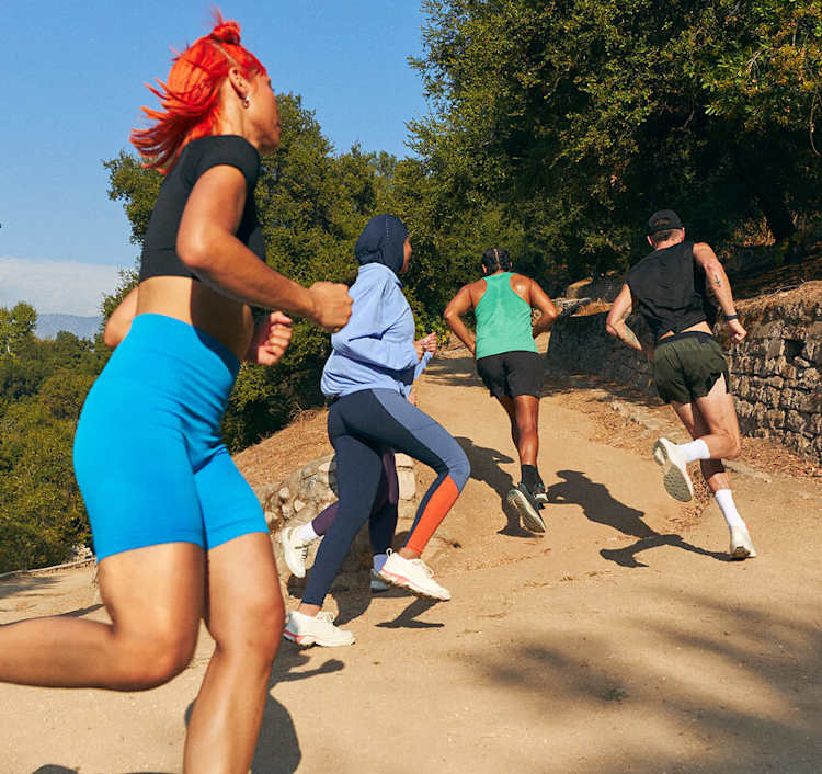 four trail runners running uphill