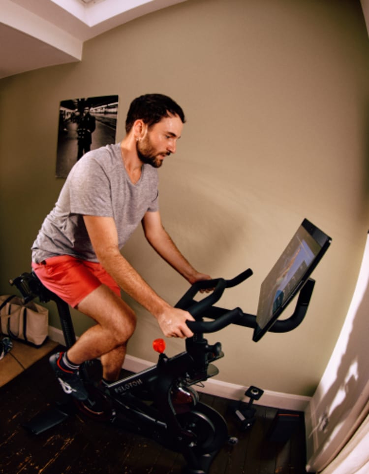 man riding peloton bike