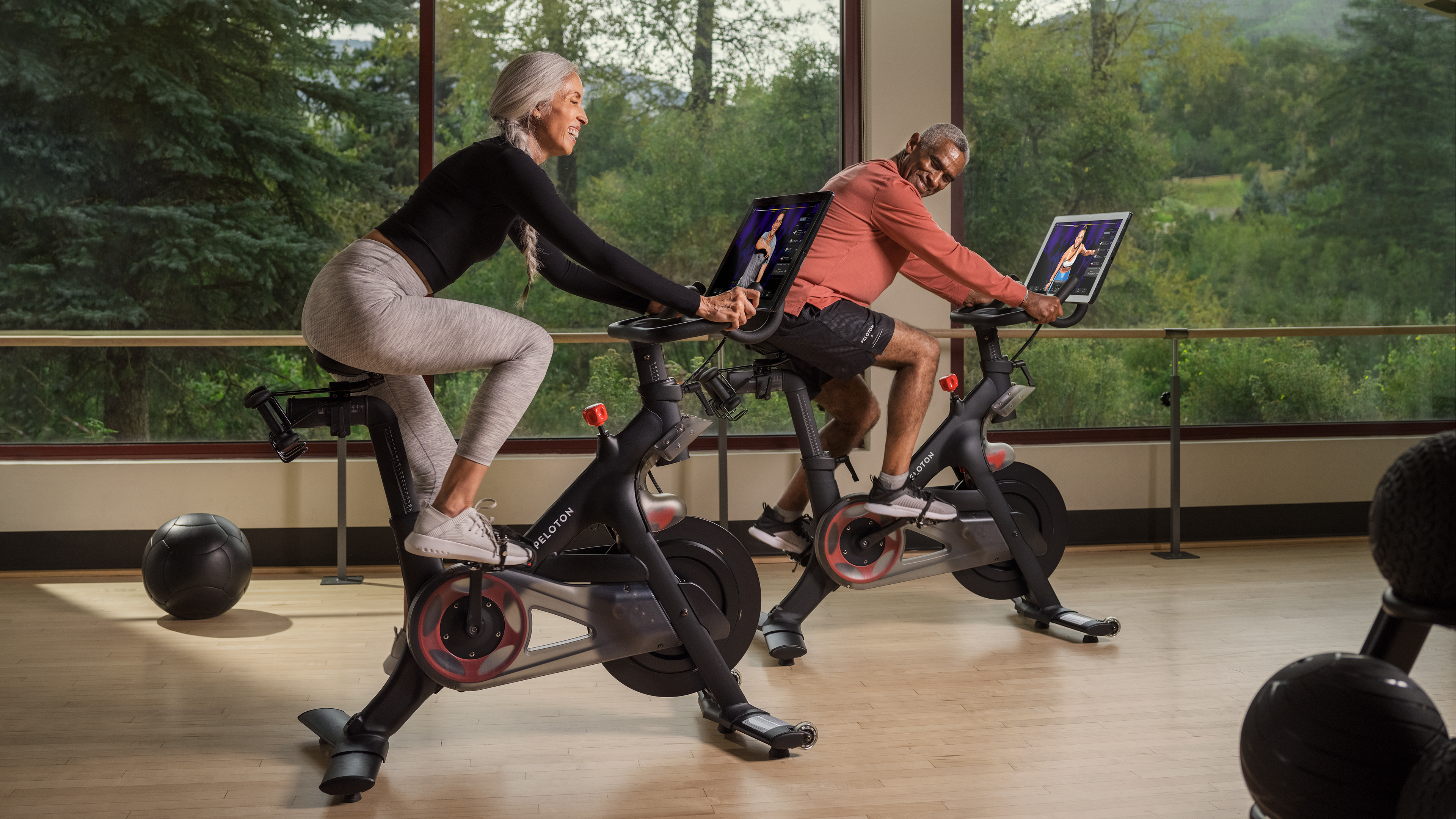 An elderly couple exercising on Peloton bikes at The Westin Riverfront Resort & Spa