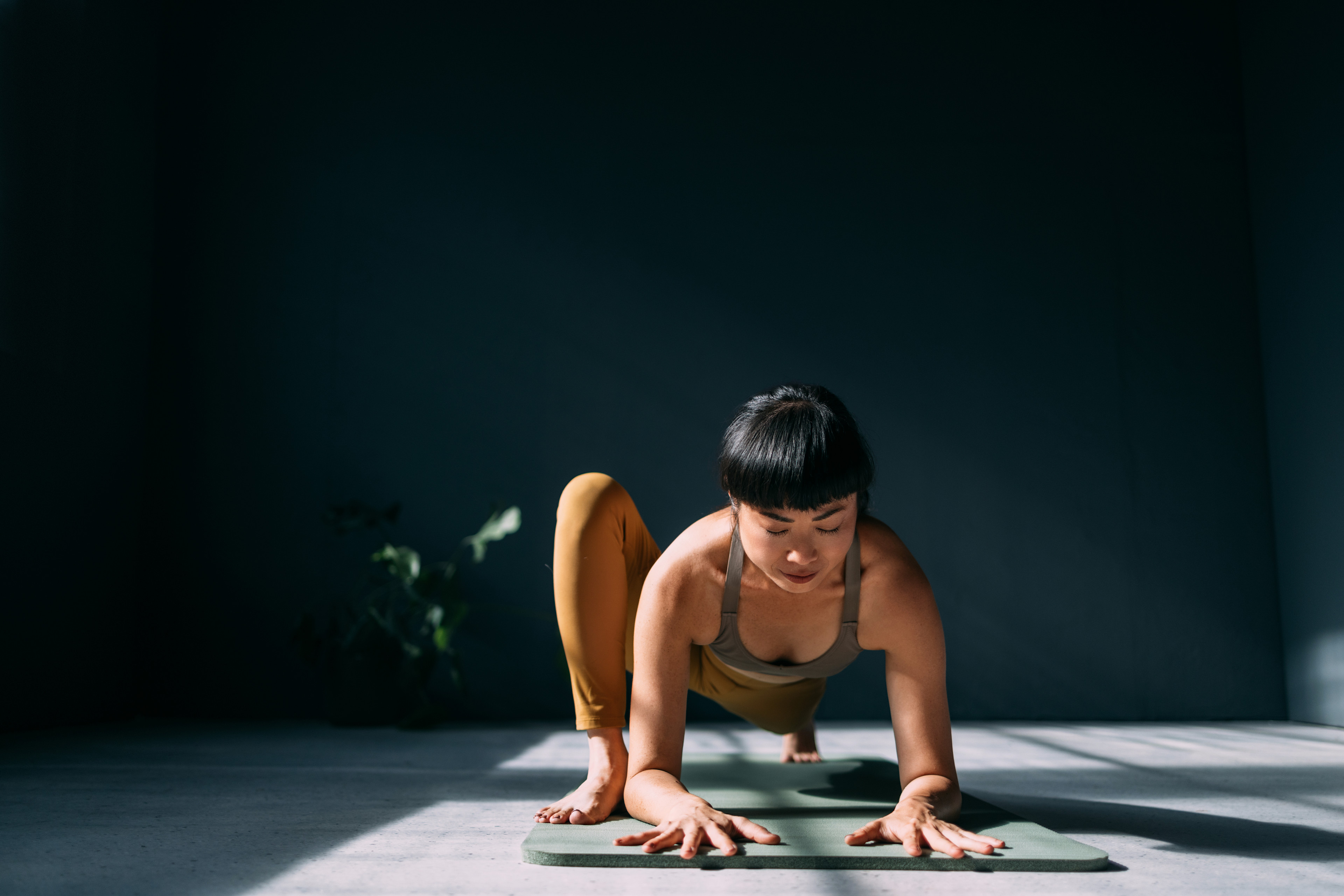 Woman doing Lizard Pose in yoga in a studio space