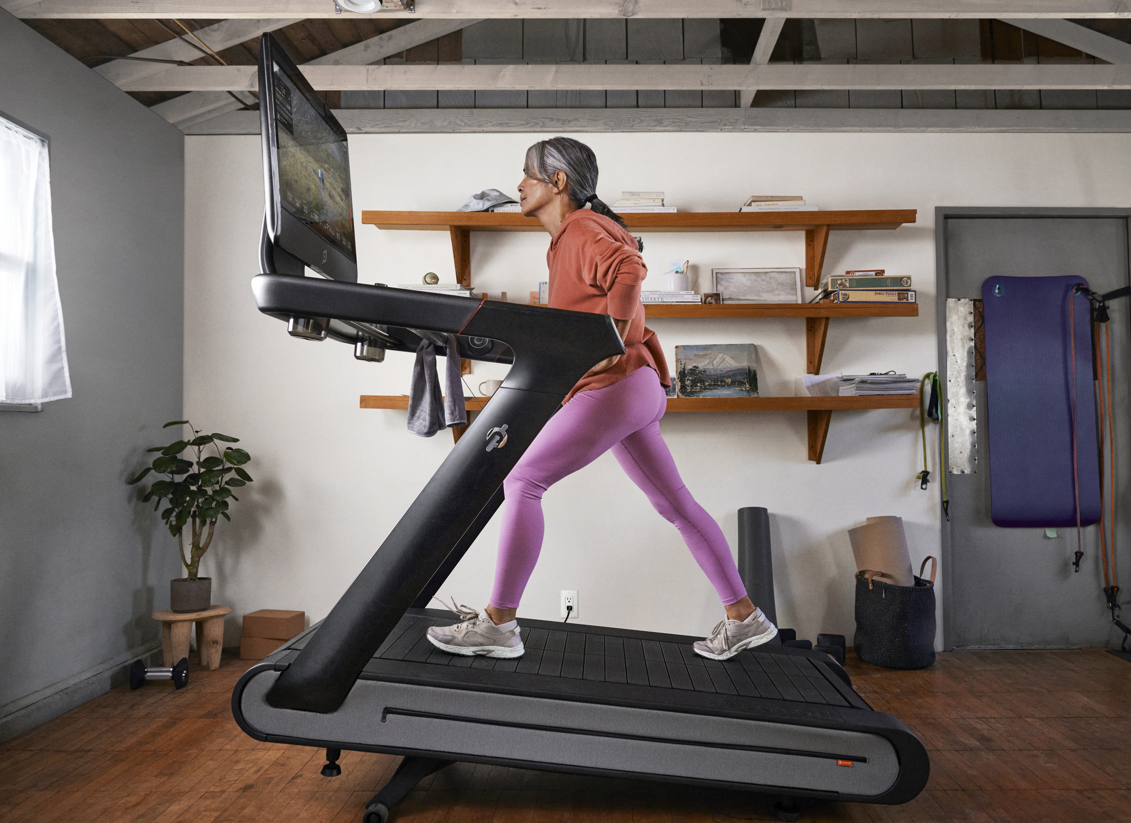 Woman runs on Peloton Tread+ at home