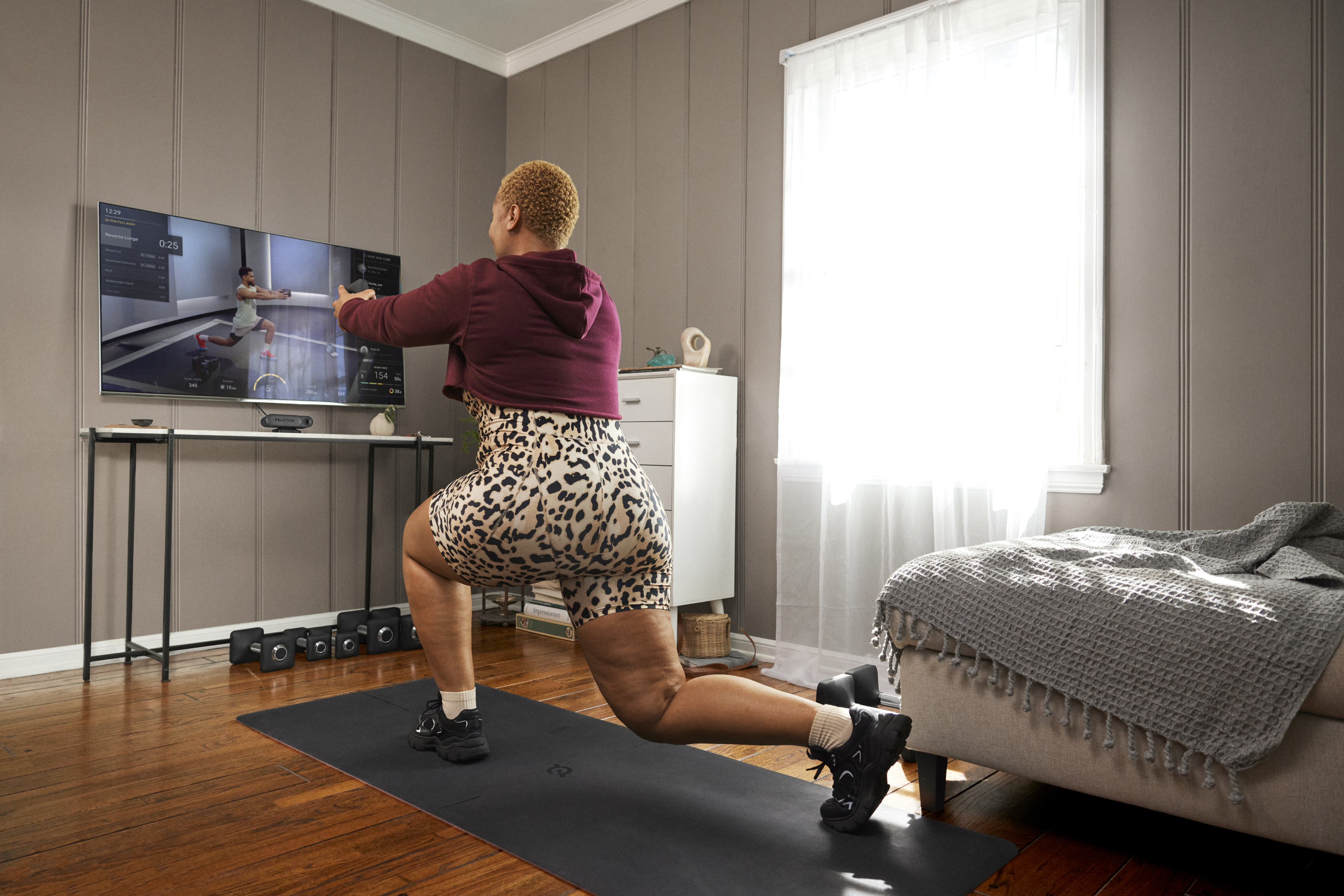 Woman works out at home with Peloton Guide