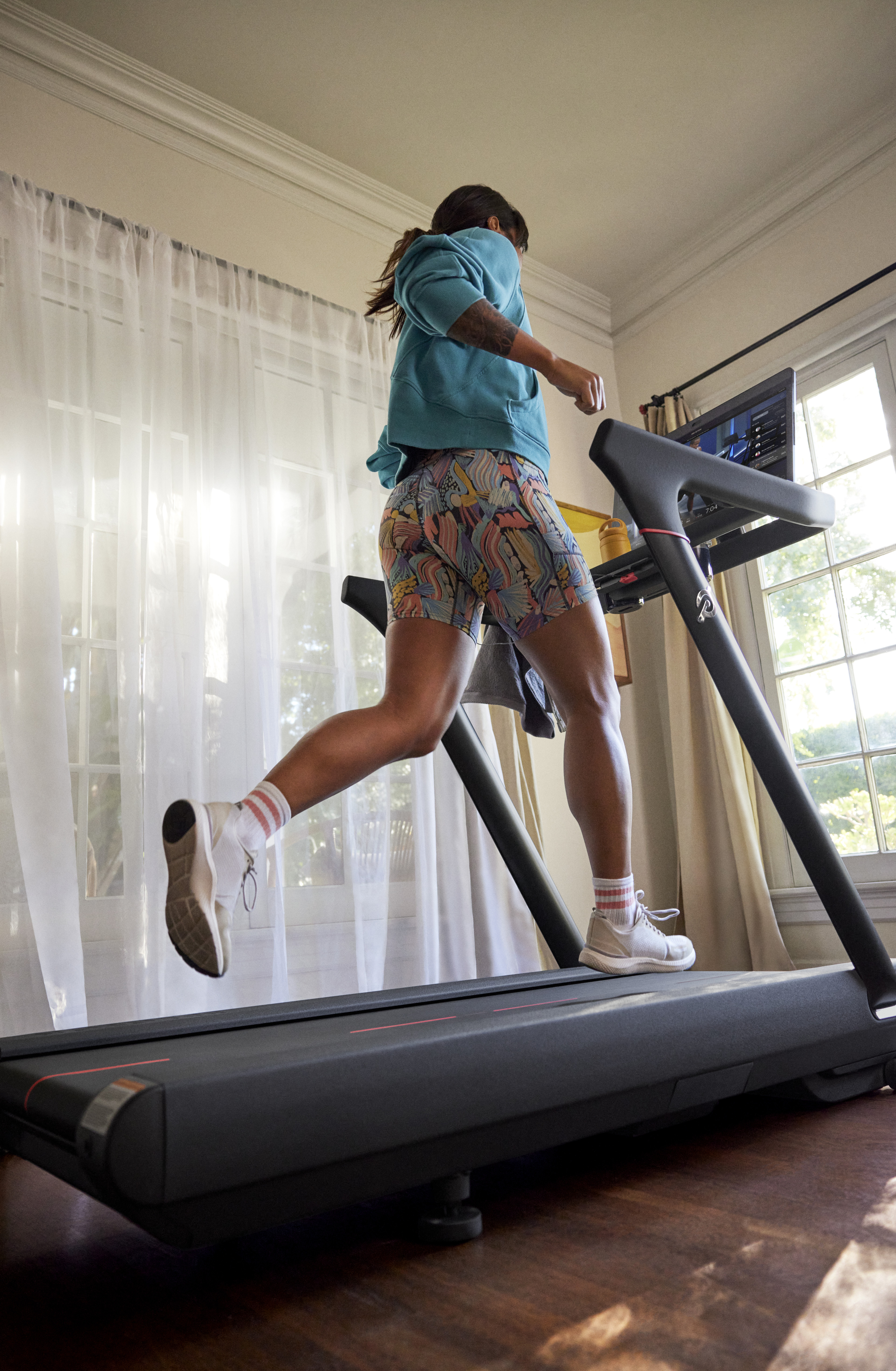 Woman runs on Peloton Tread at home