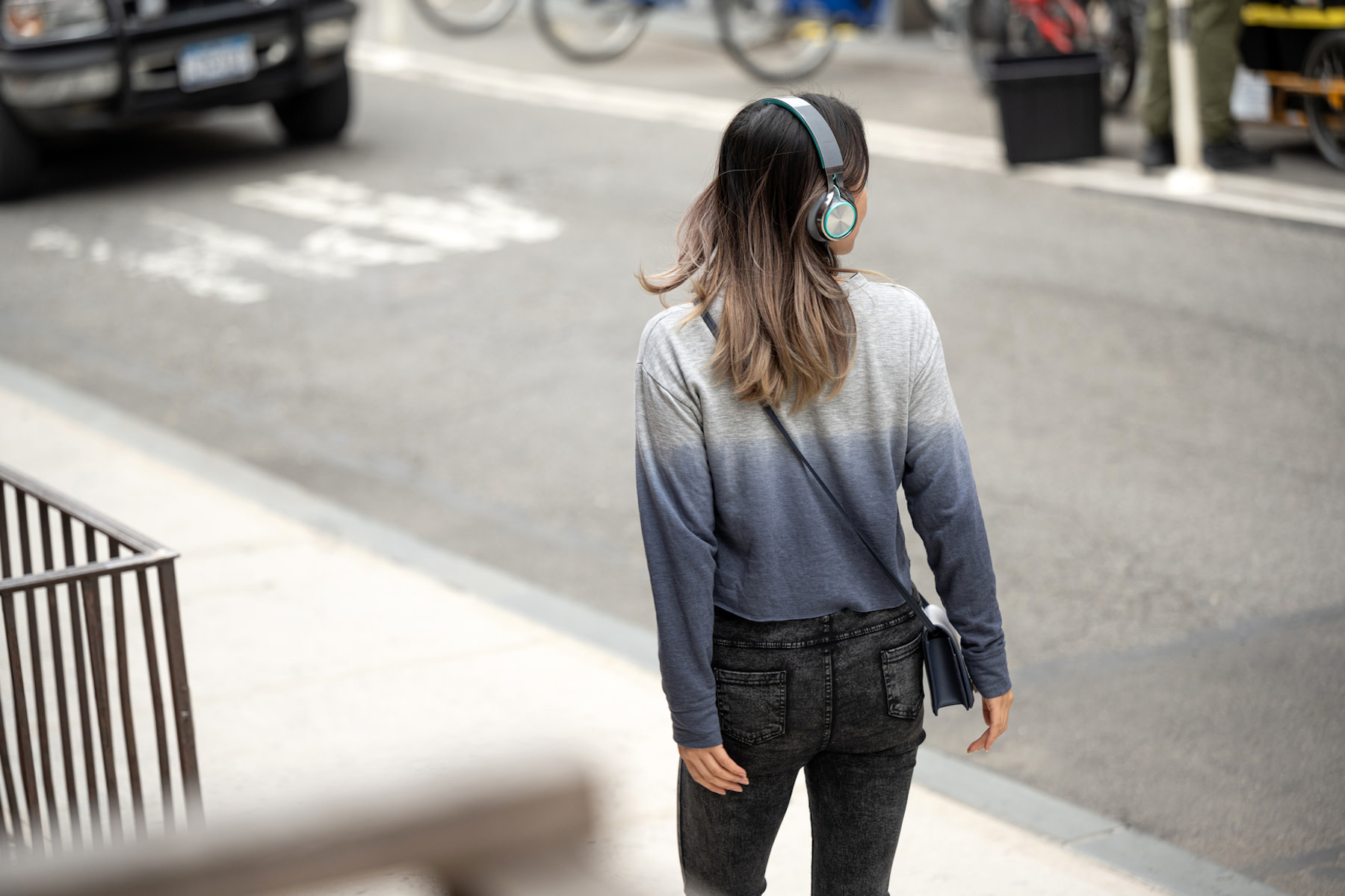 A woman going on a walking meditation outside while wearing headphones. Walking meditations are a form of mindful movement.