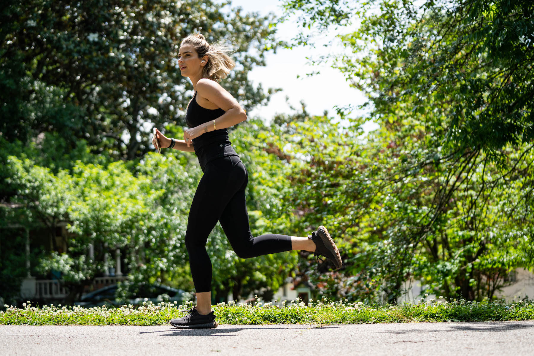 A woman runs a mile outside with headphones 