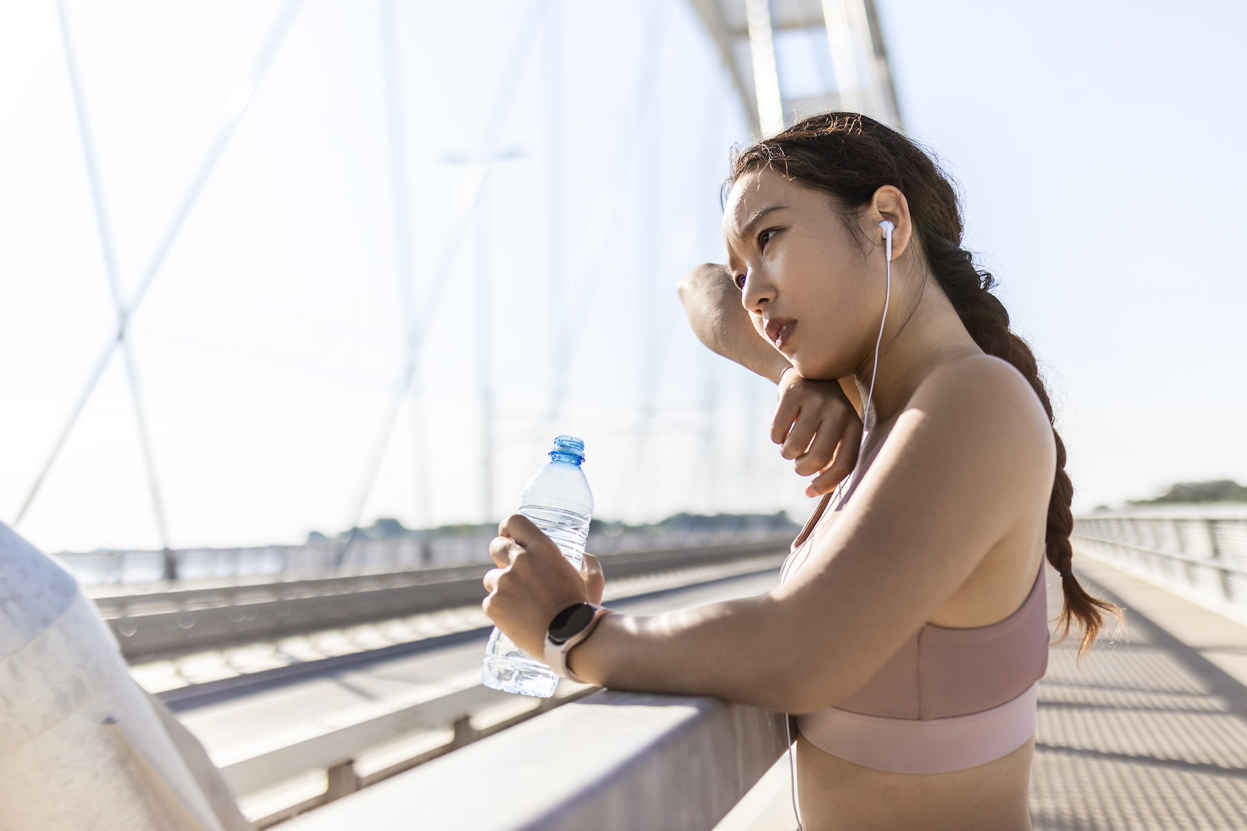 A tired athlete resting and drinking water after shaking after a workout.