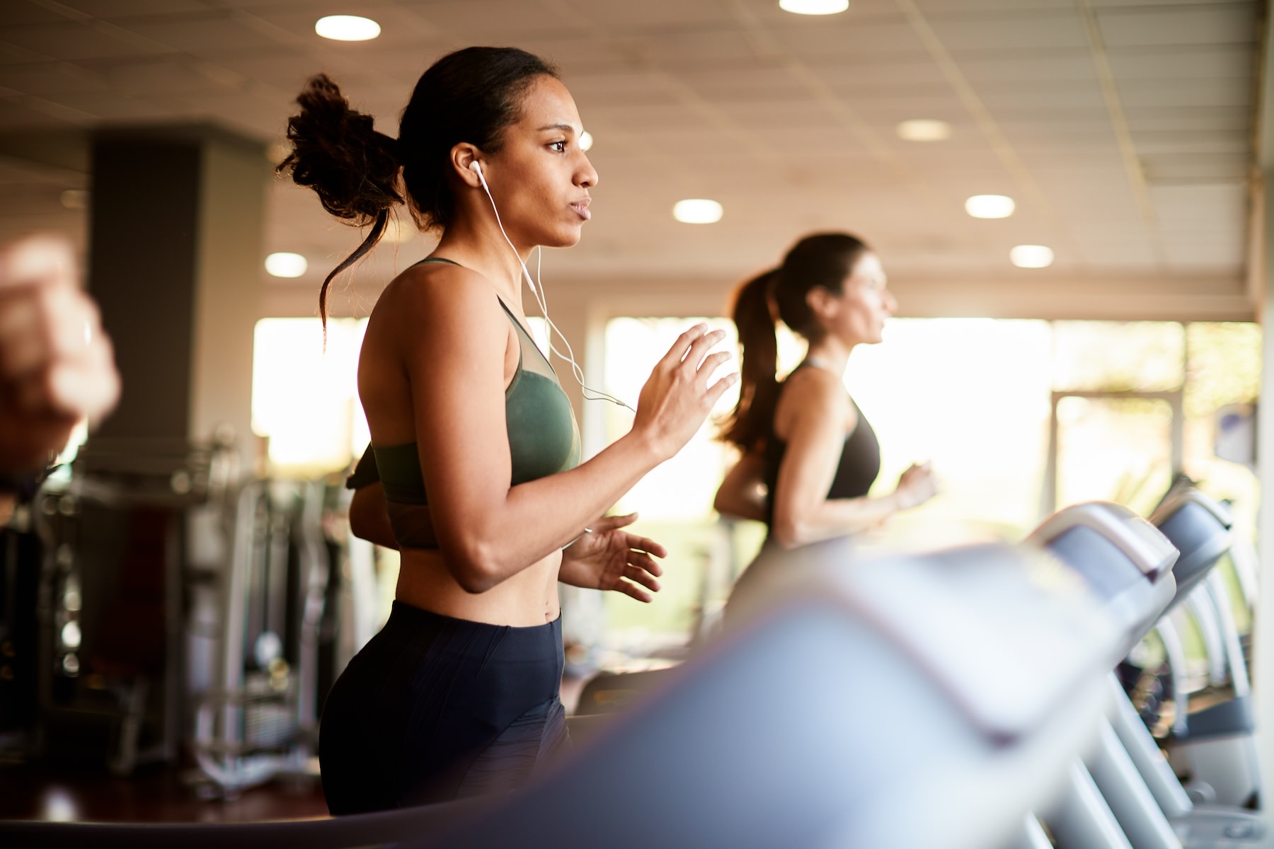 A woman running on a treadmill at the gym.