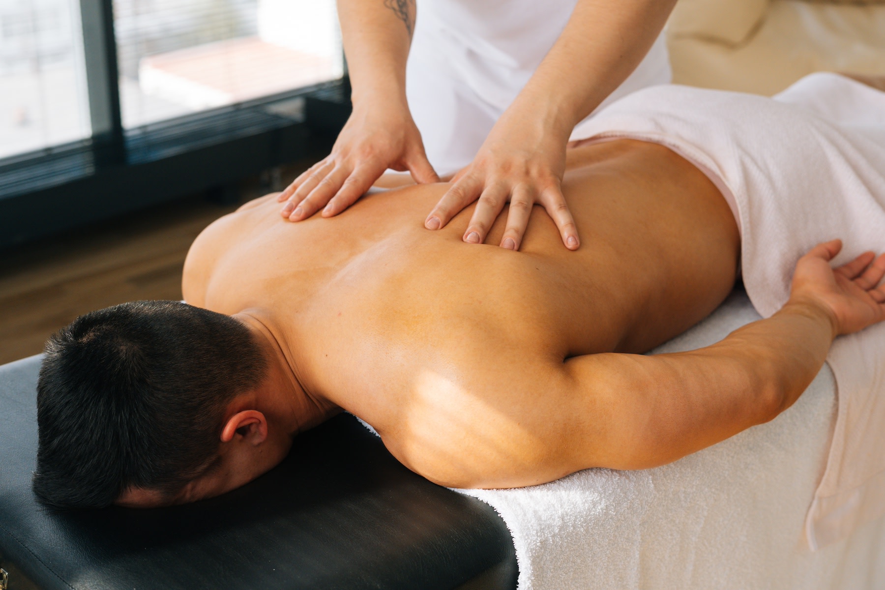 A man getting a massage after a workout by a licensed massage therapist.