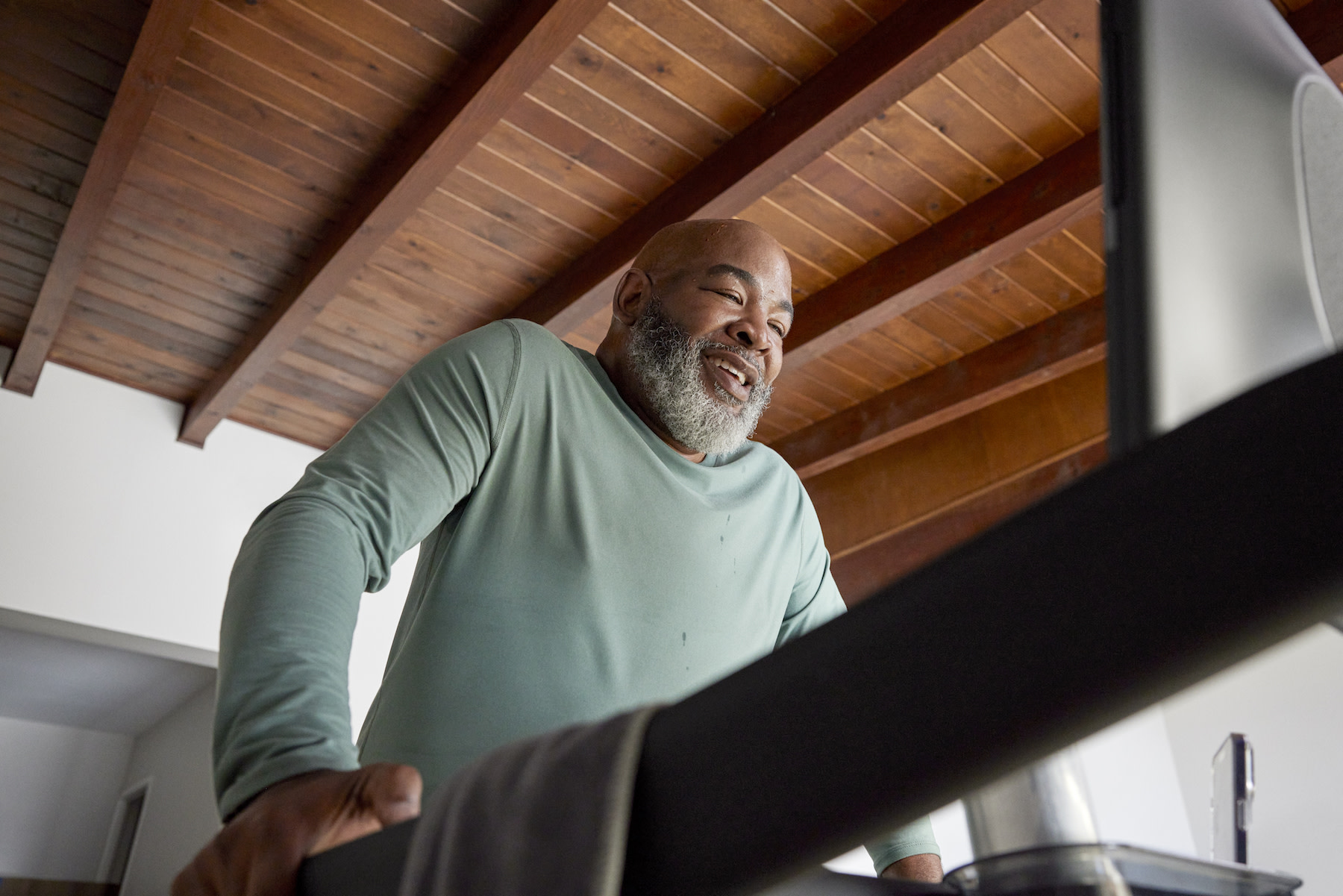 A man happily exercising while walking on the Tread. Learn more about how exercise relieves stress in this article.