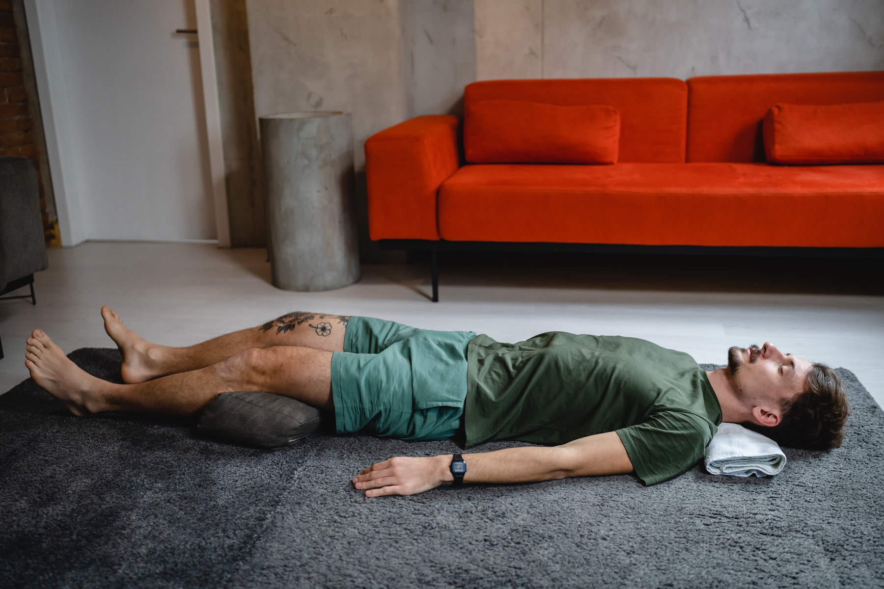 Man rests in Savasana, a restorative yoga pose