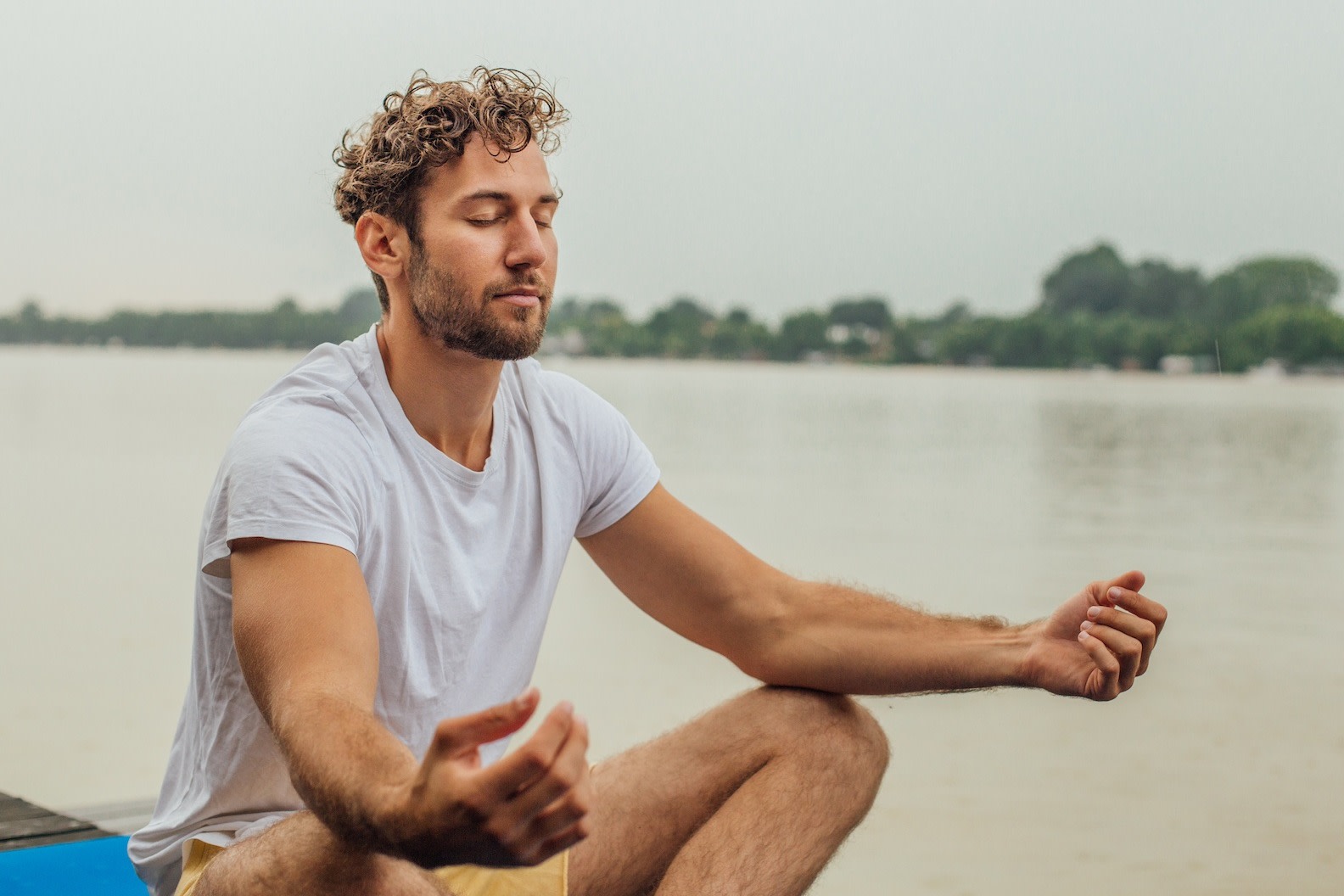 A man meditating outside to strengthen his mind-body connection.