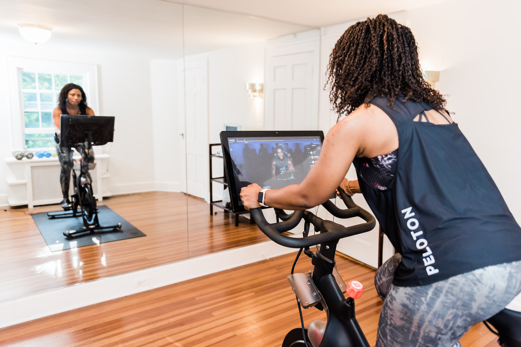 Woman rides Peloton Bike at home