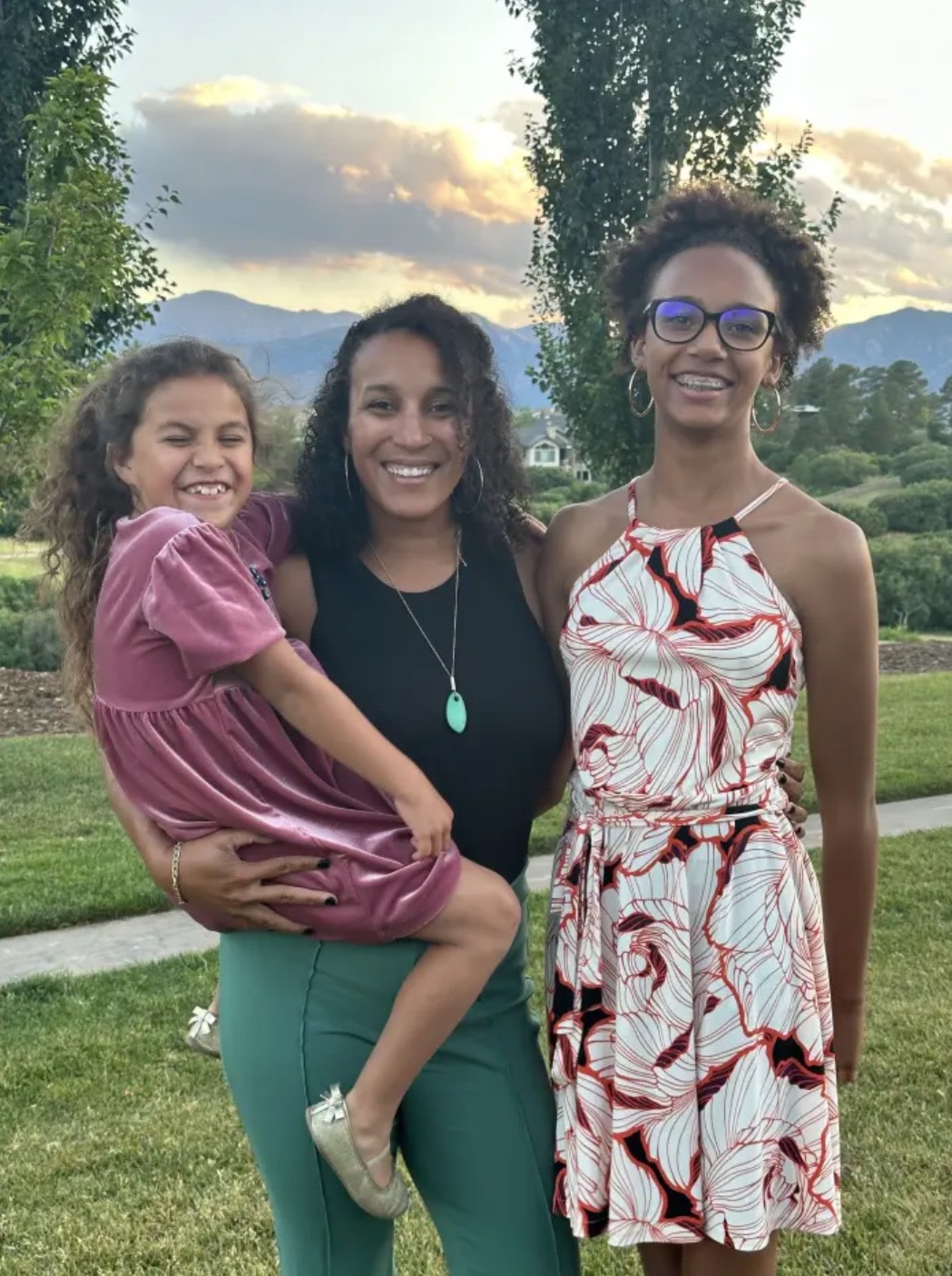 A Peloton Member smiling, posing with 2 children
