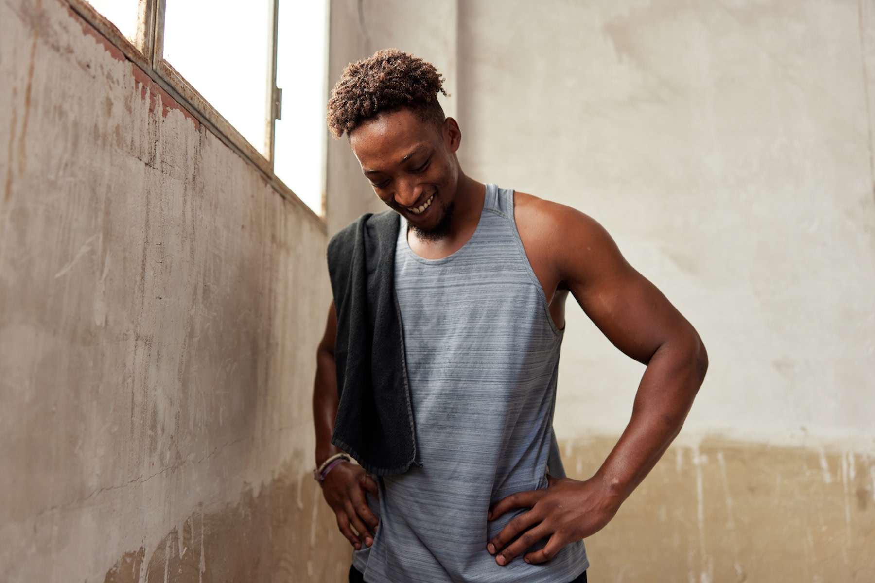 A male athlete smiling and looking resilient while at the gym. Learn how to build resilience in this article.