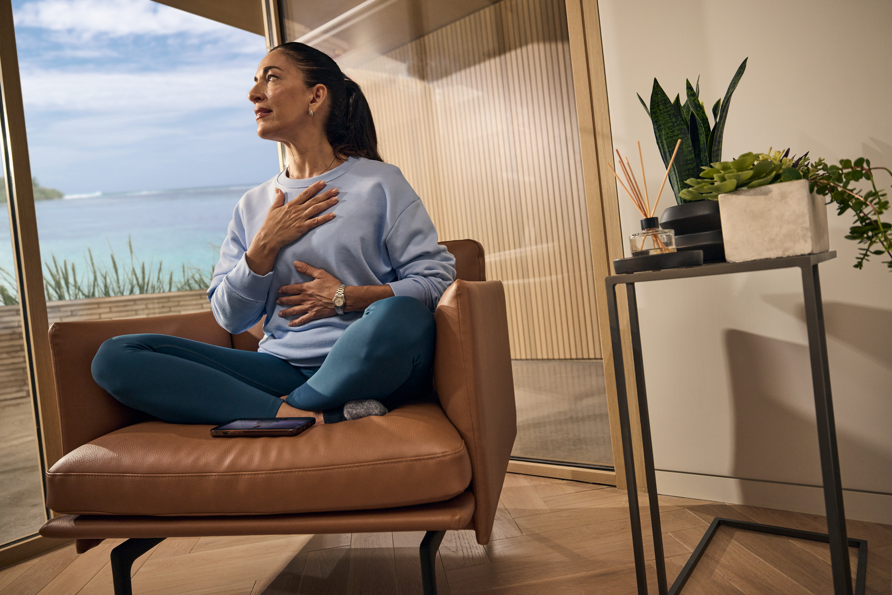 A hotel guest practicing mediation while seated next to the window