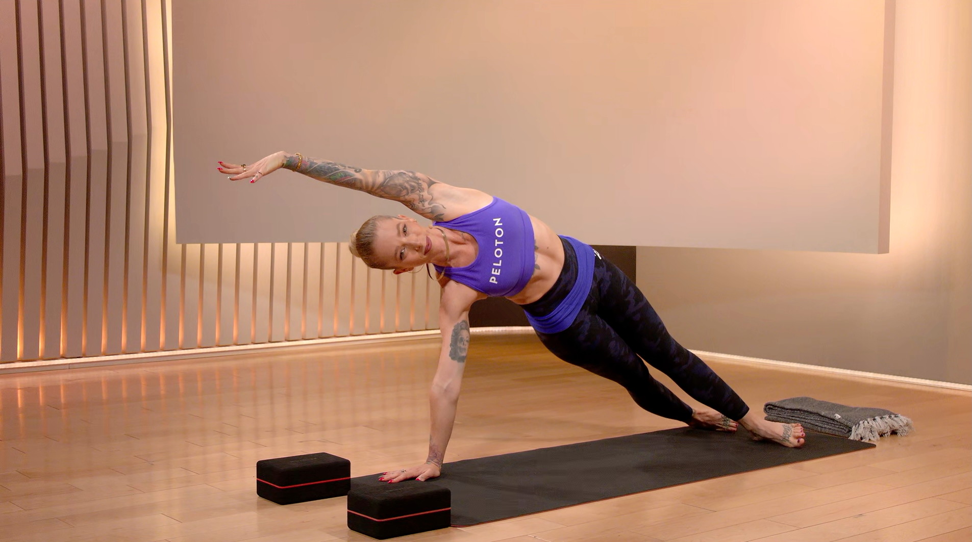 Peloton instructor Kirra Michel demonstrates a side plank during a yoga class on the Peloton App
