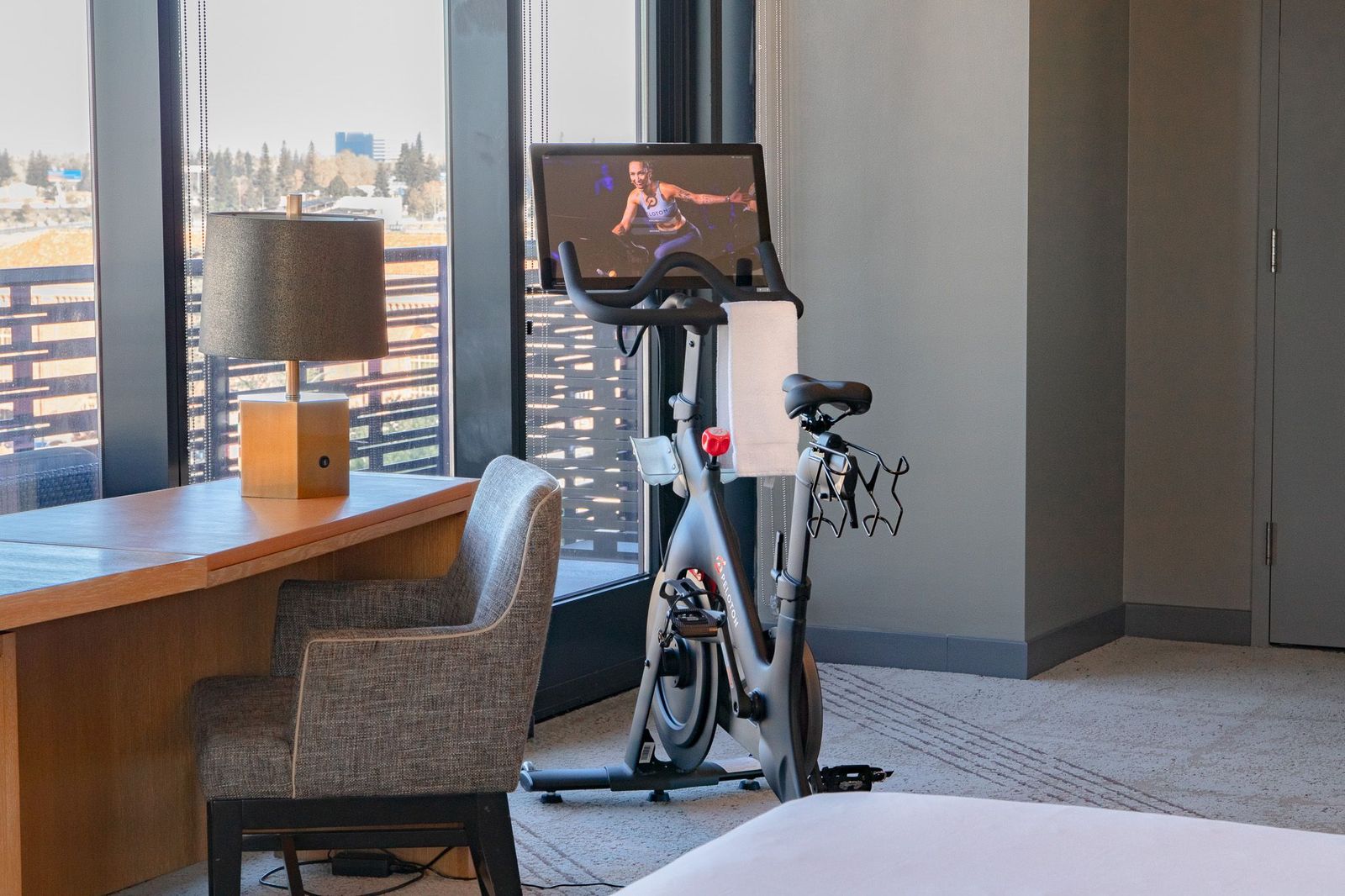 Peloton Bike next to desk and chair in a Sweat Suite at the Kimpton Sawyer Hotel