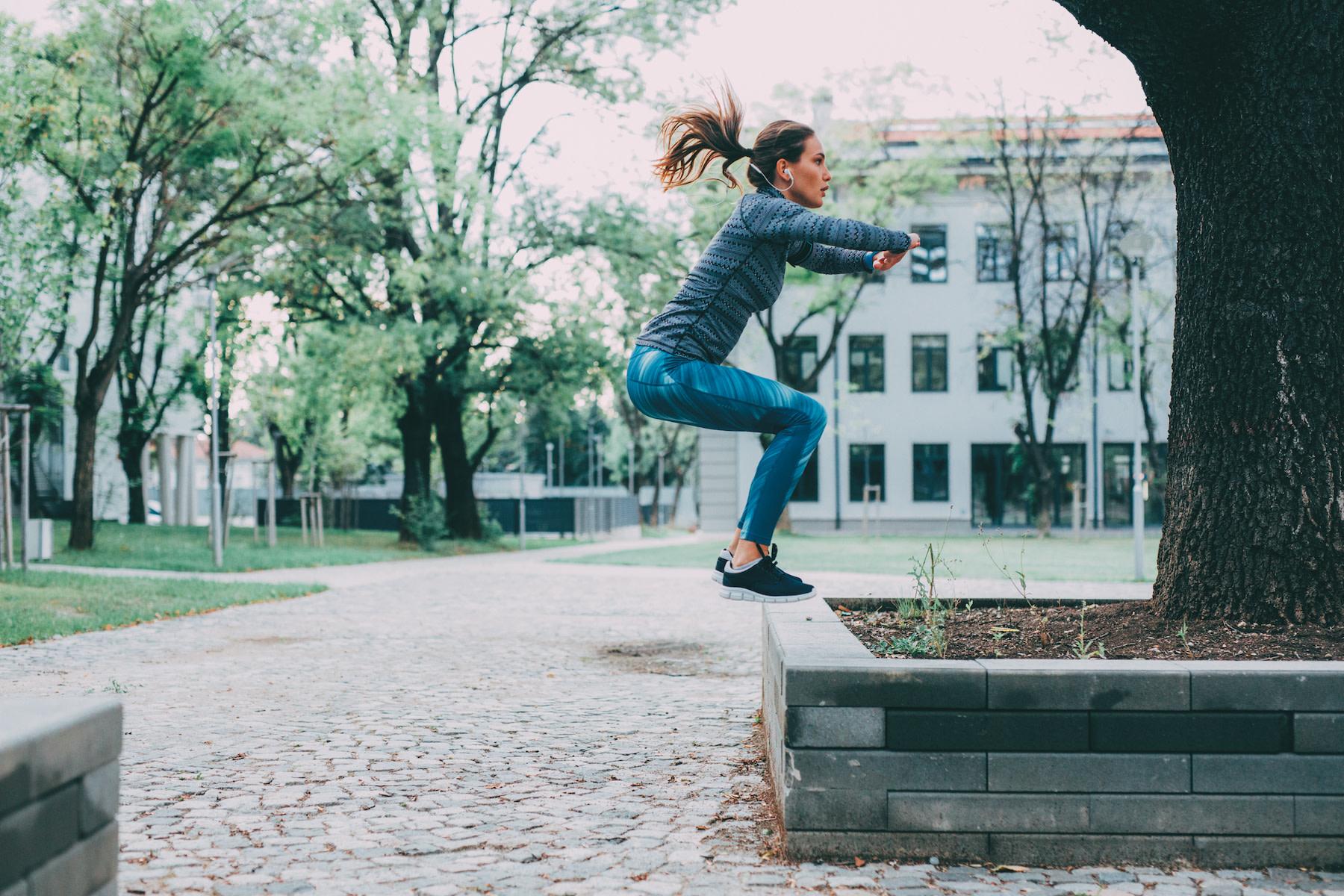 Woman does a jump squat, one of the best plyometric exercises