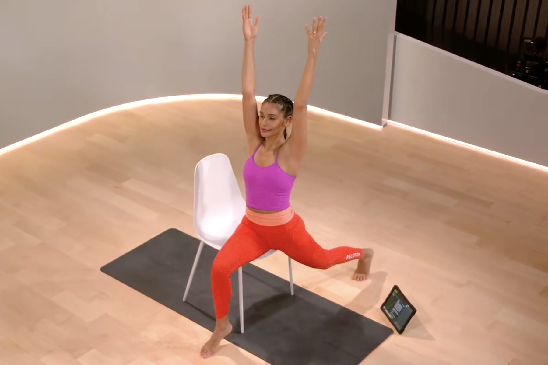 Woman does a seated warrior 1 during chair yoga