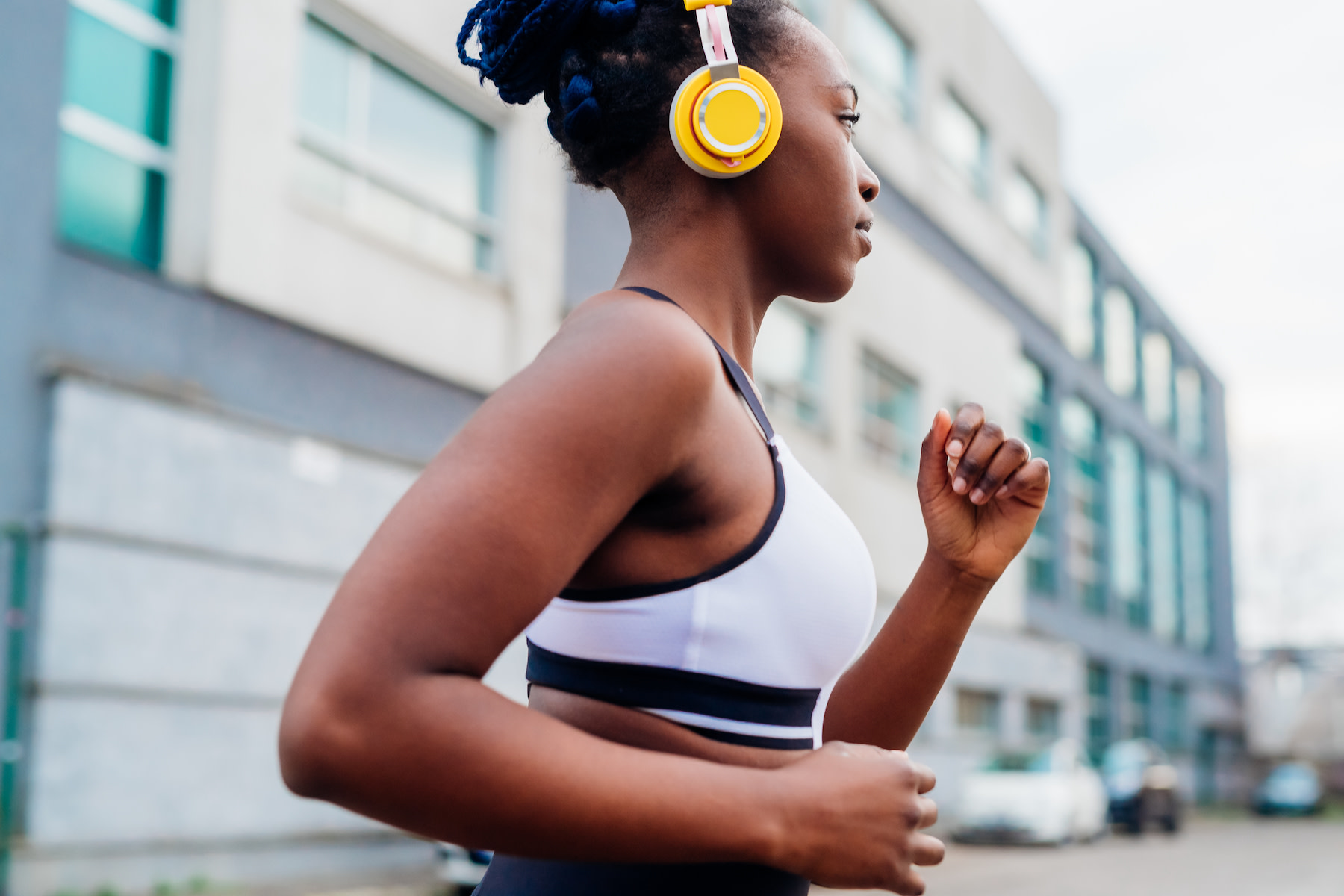 A woman jogging with headphones on outside. Jogging can be a form of mindful movement.