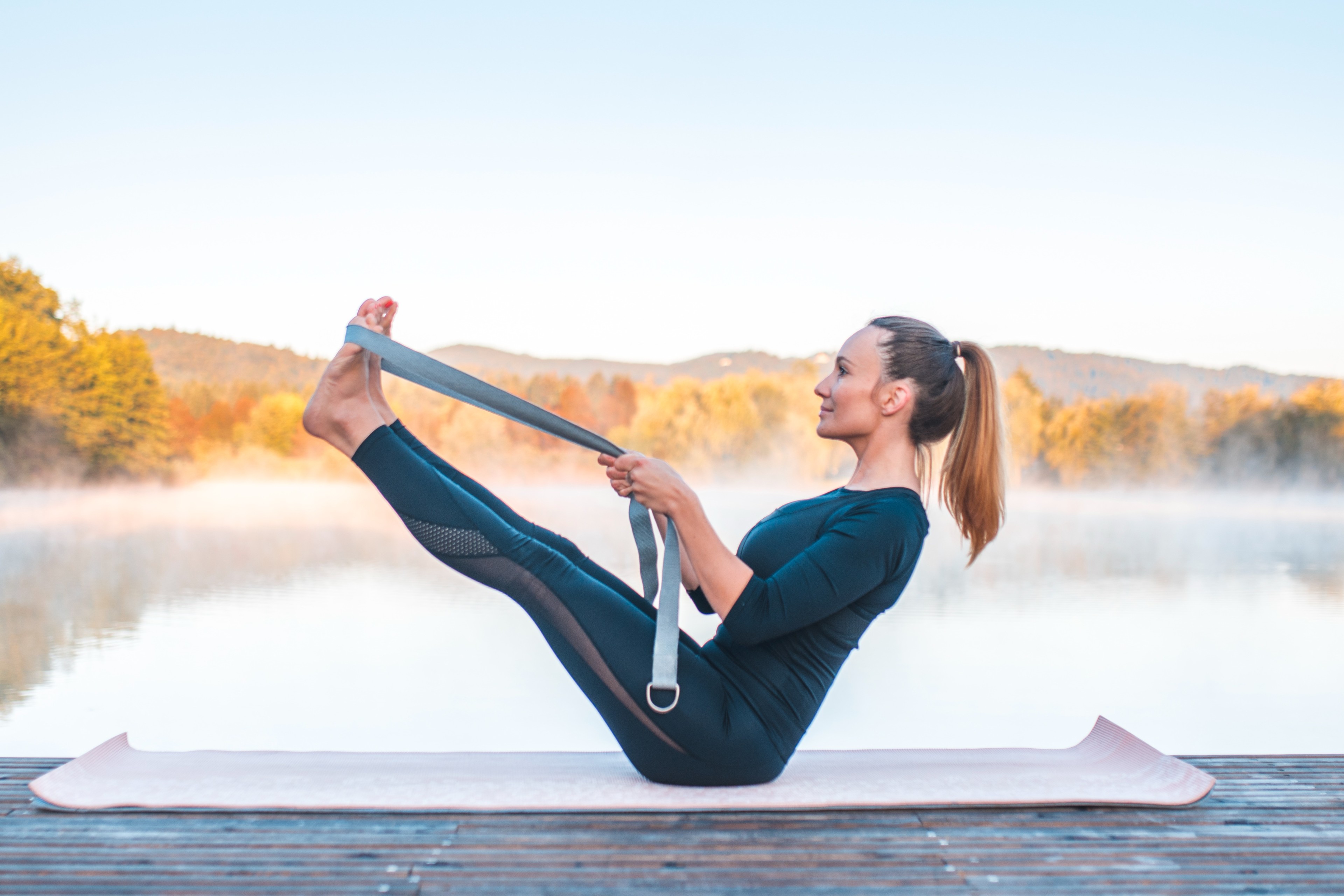 Woman doing Boat Pose with Strap