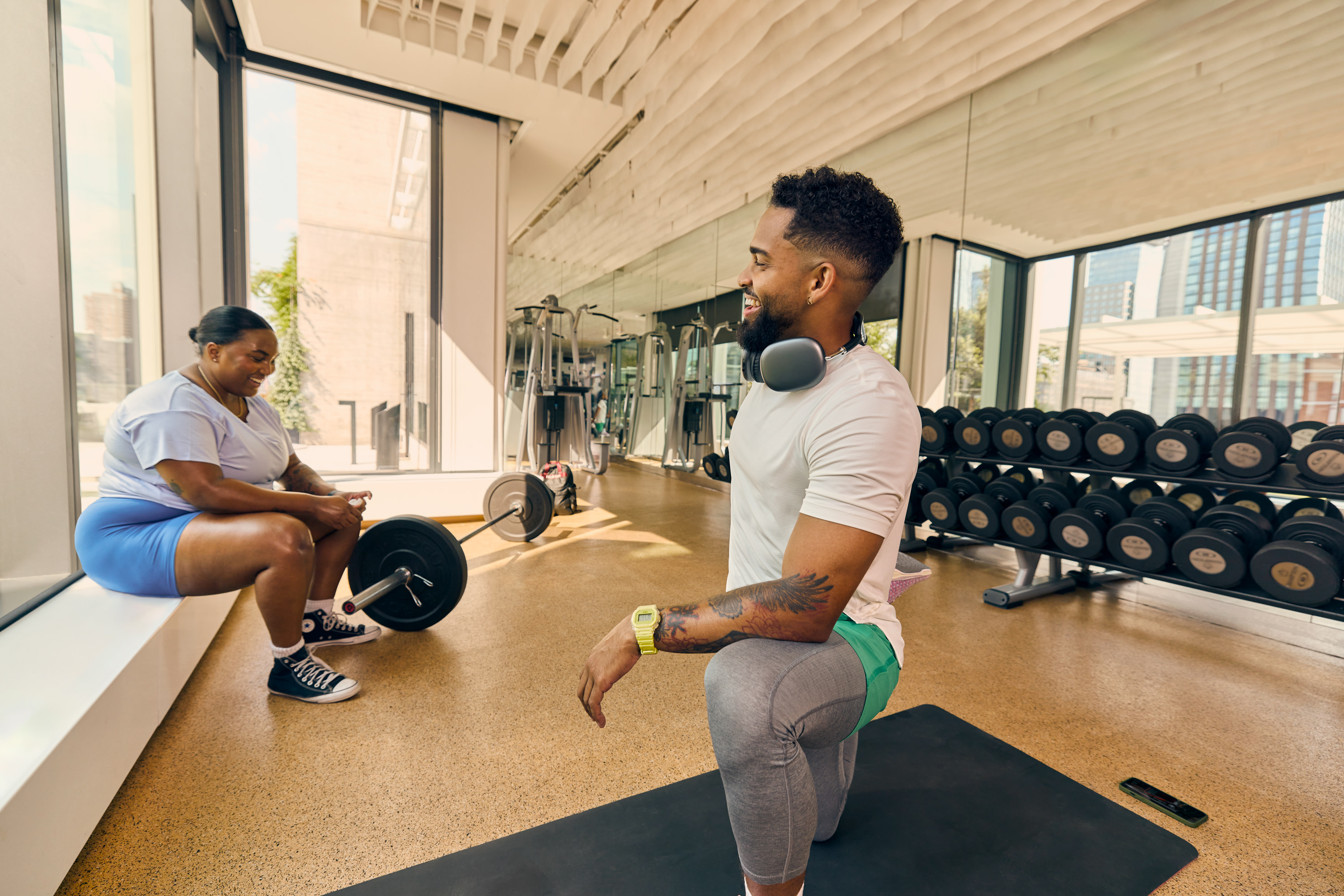 2 exercisers interacting in a gym, during strength training