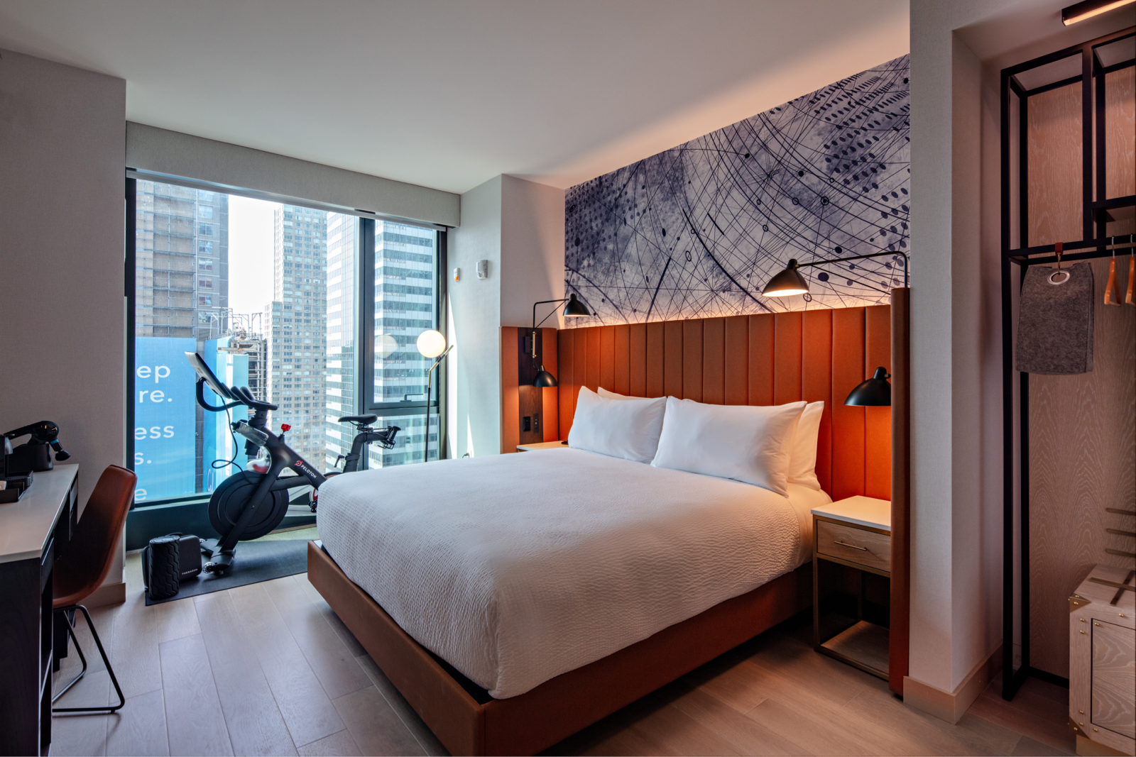 A Hilton hotel room with a Peloton Bike next to the bed
