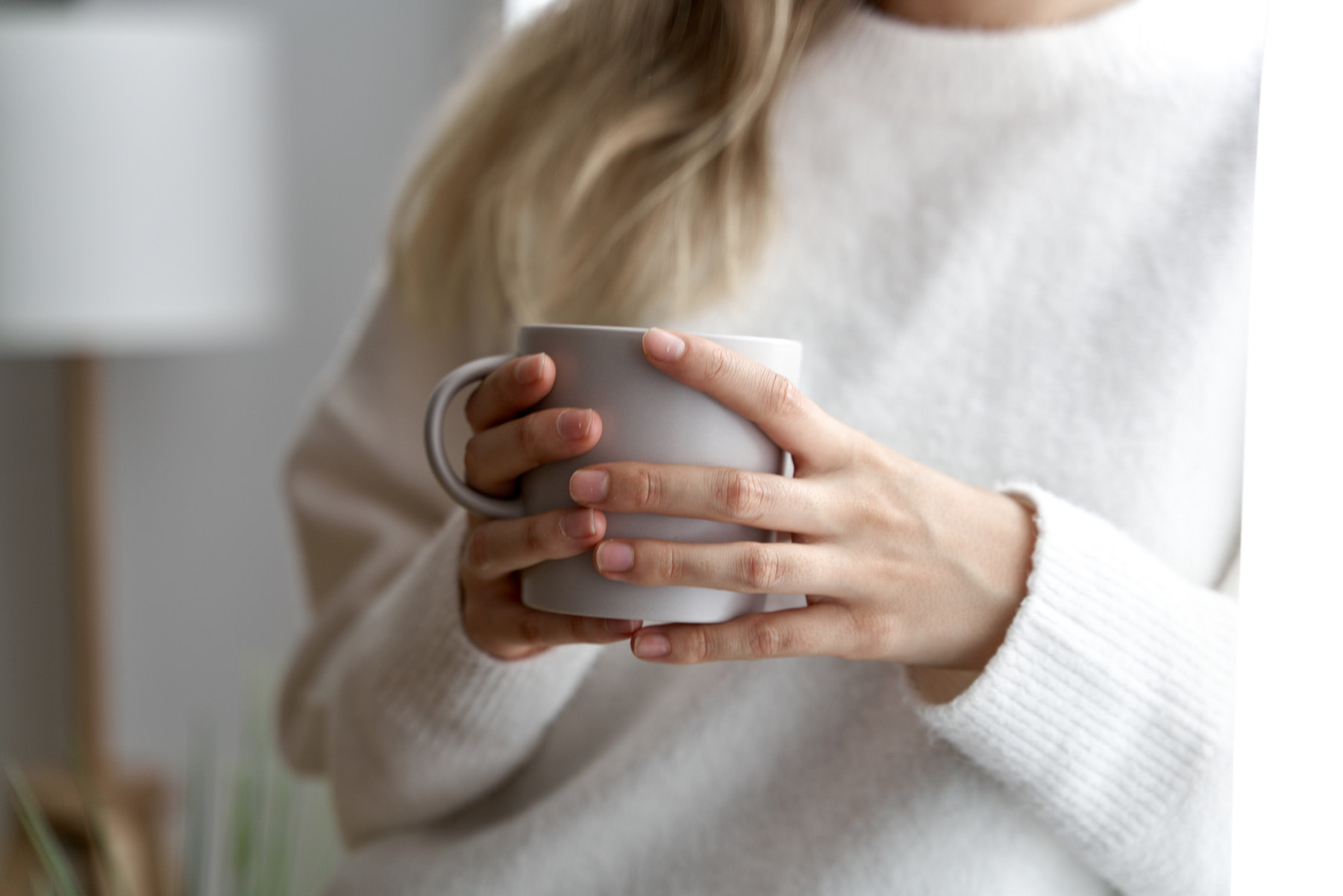 Does Coffee Dehydrate You?: A close-up photo of a person holding a mug of coffee.