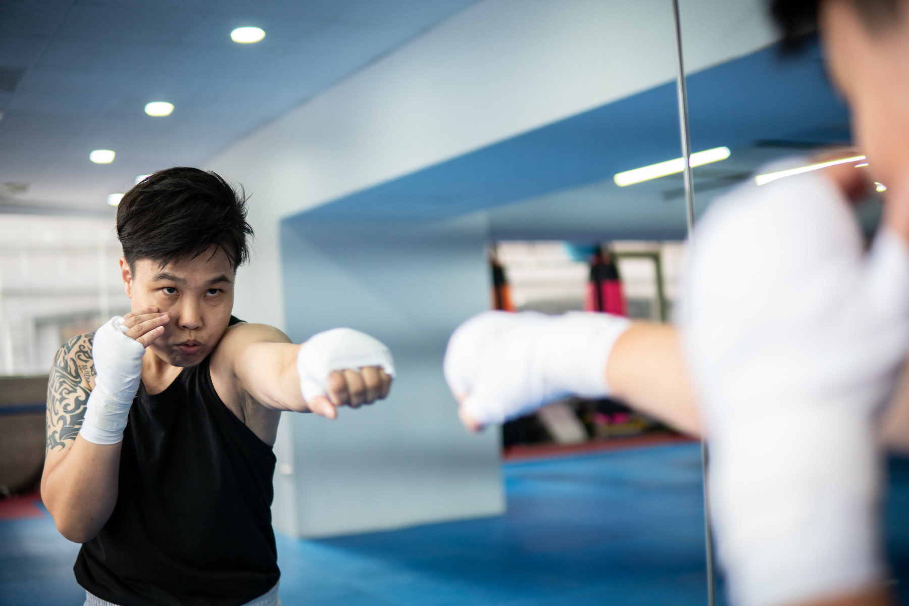 Person does jabs during a boxing workout in front of a mirror