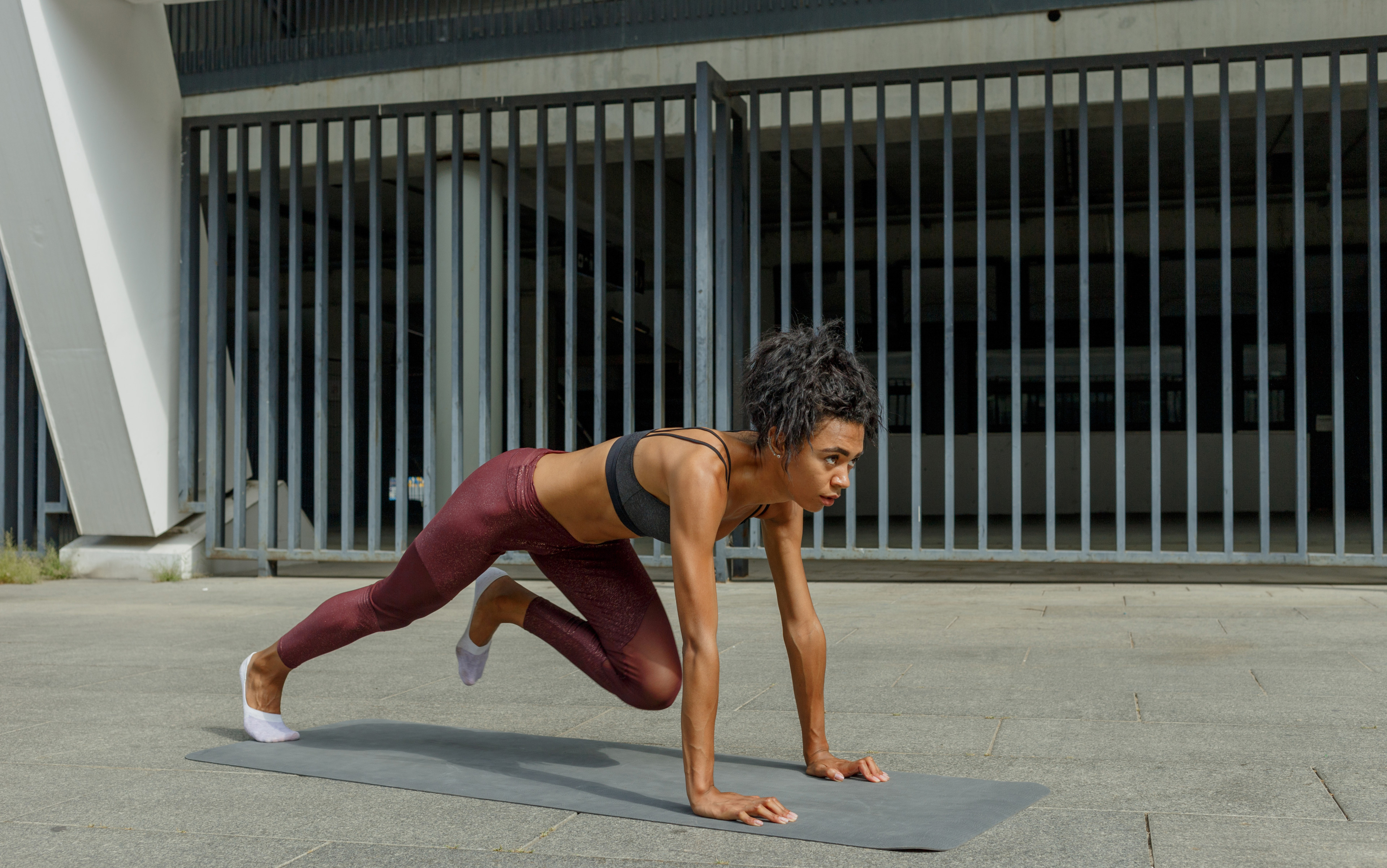 Woman outdoors performs mountain climbers exercise