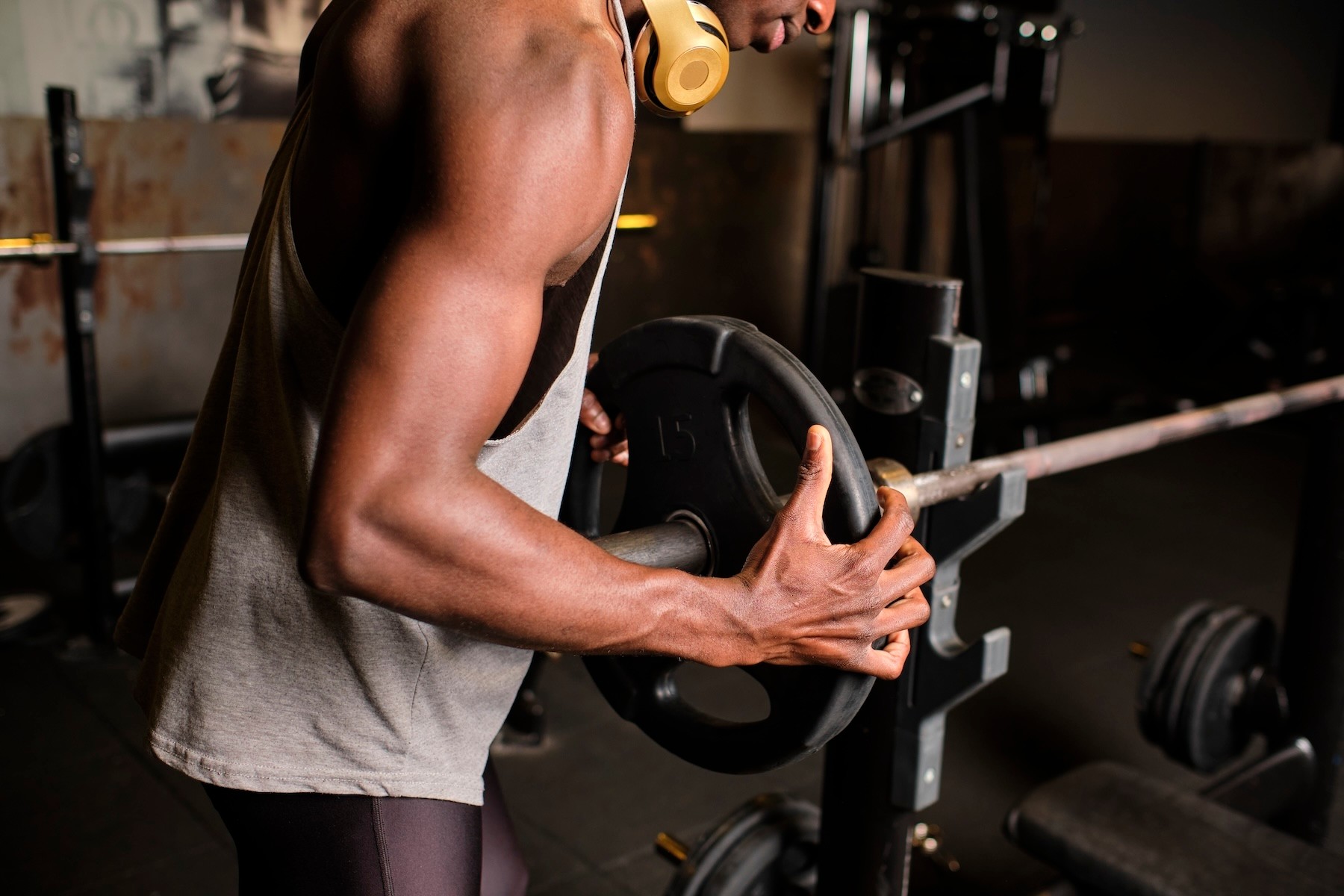 A man racking a weight plate onto a barbell.