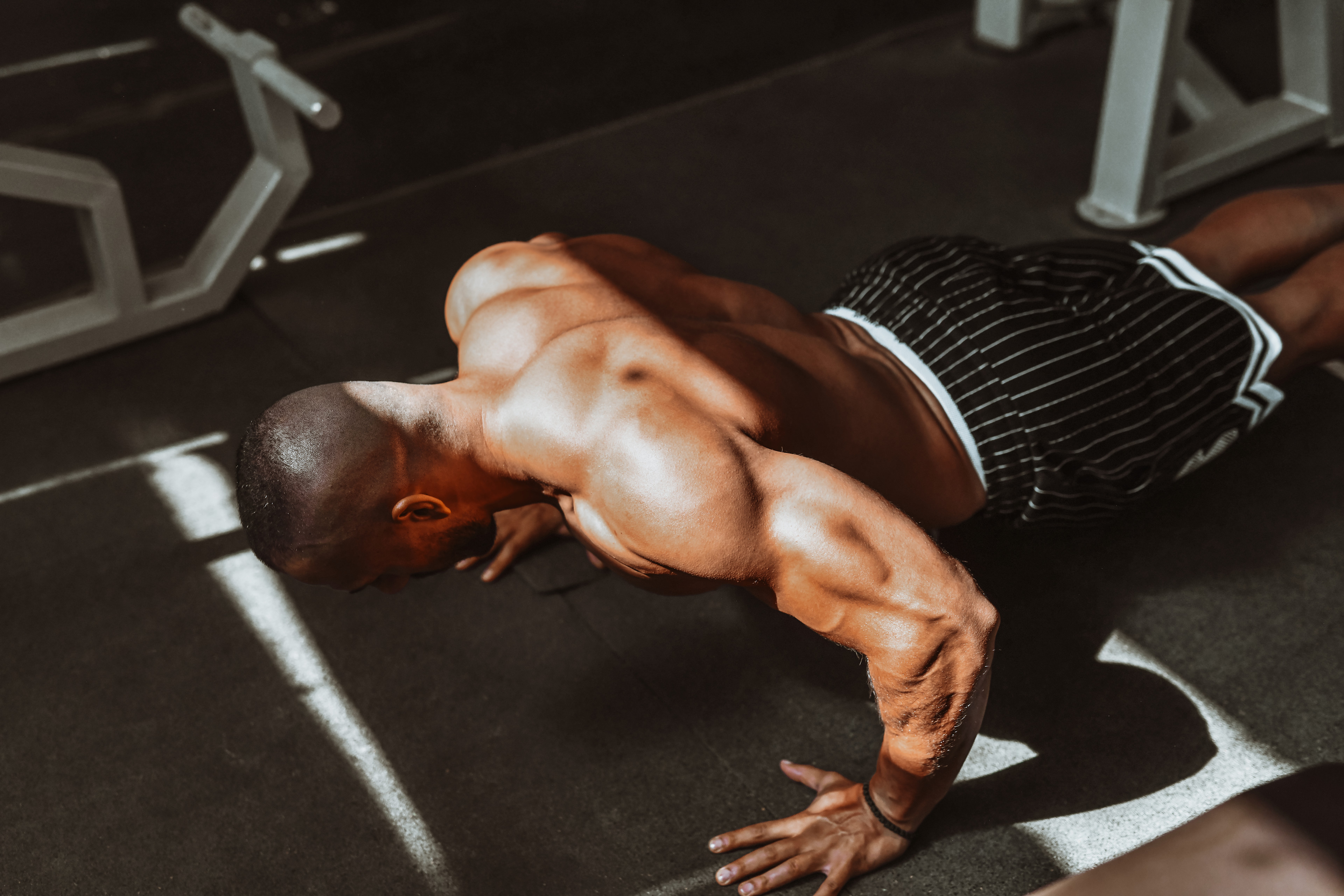 Man doing bodyweight back exercises in a gym.