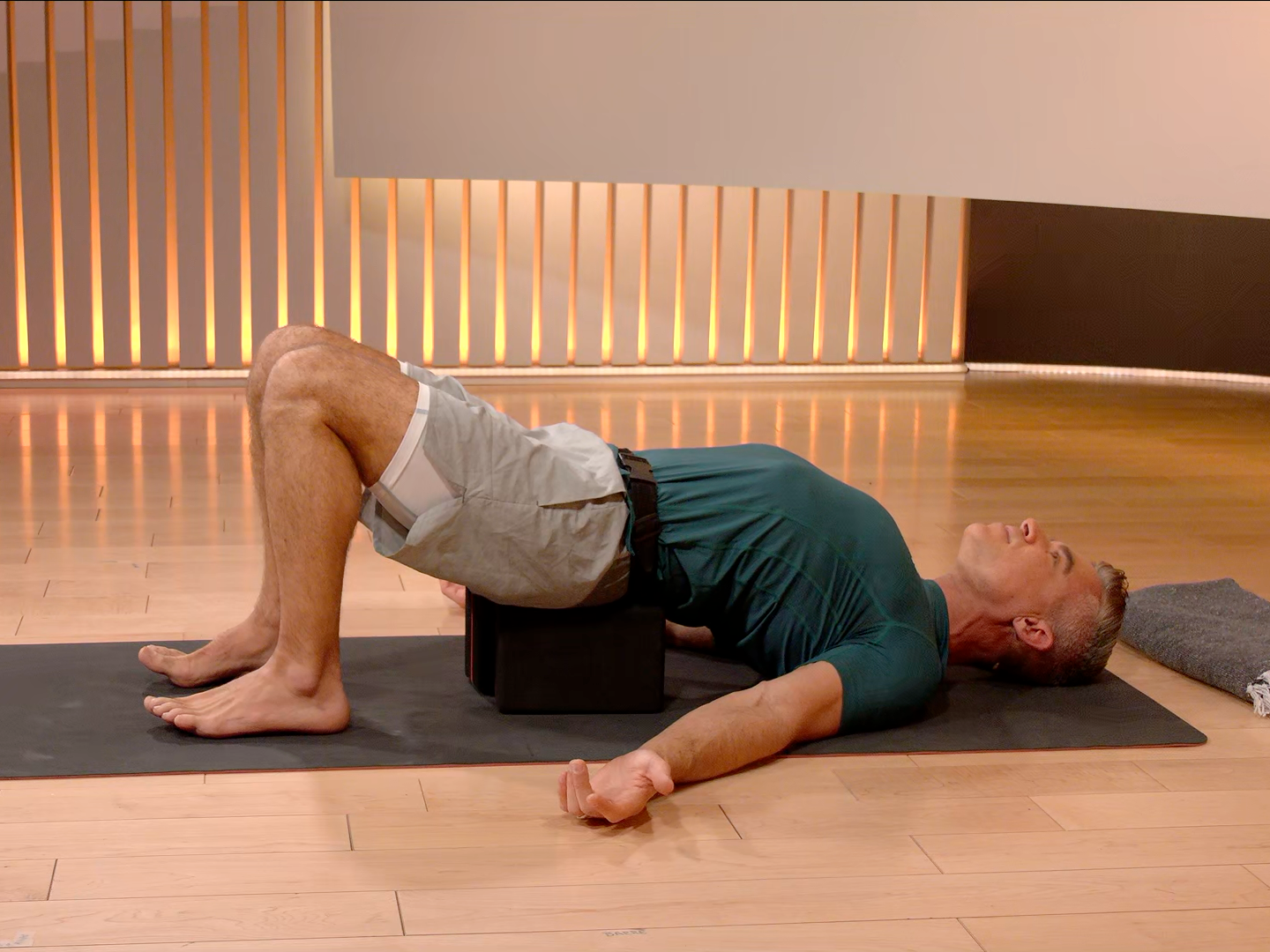 Ross Rayburn in Bridge Pose on yoga mat 