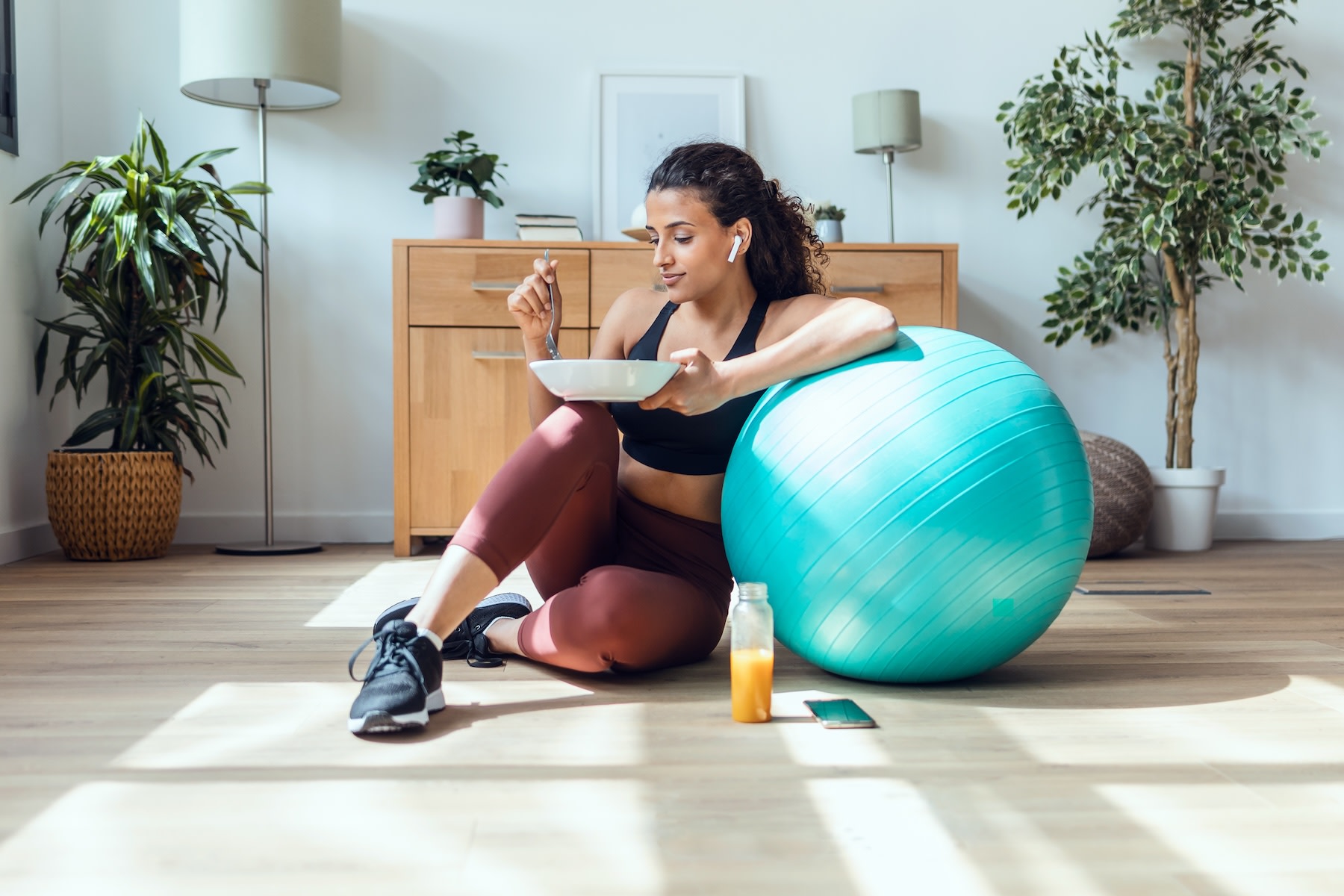 A woman eating a meal that has amino acids for muscle growth in it after a workout.