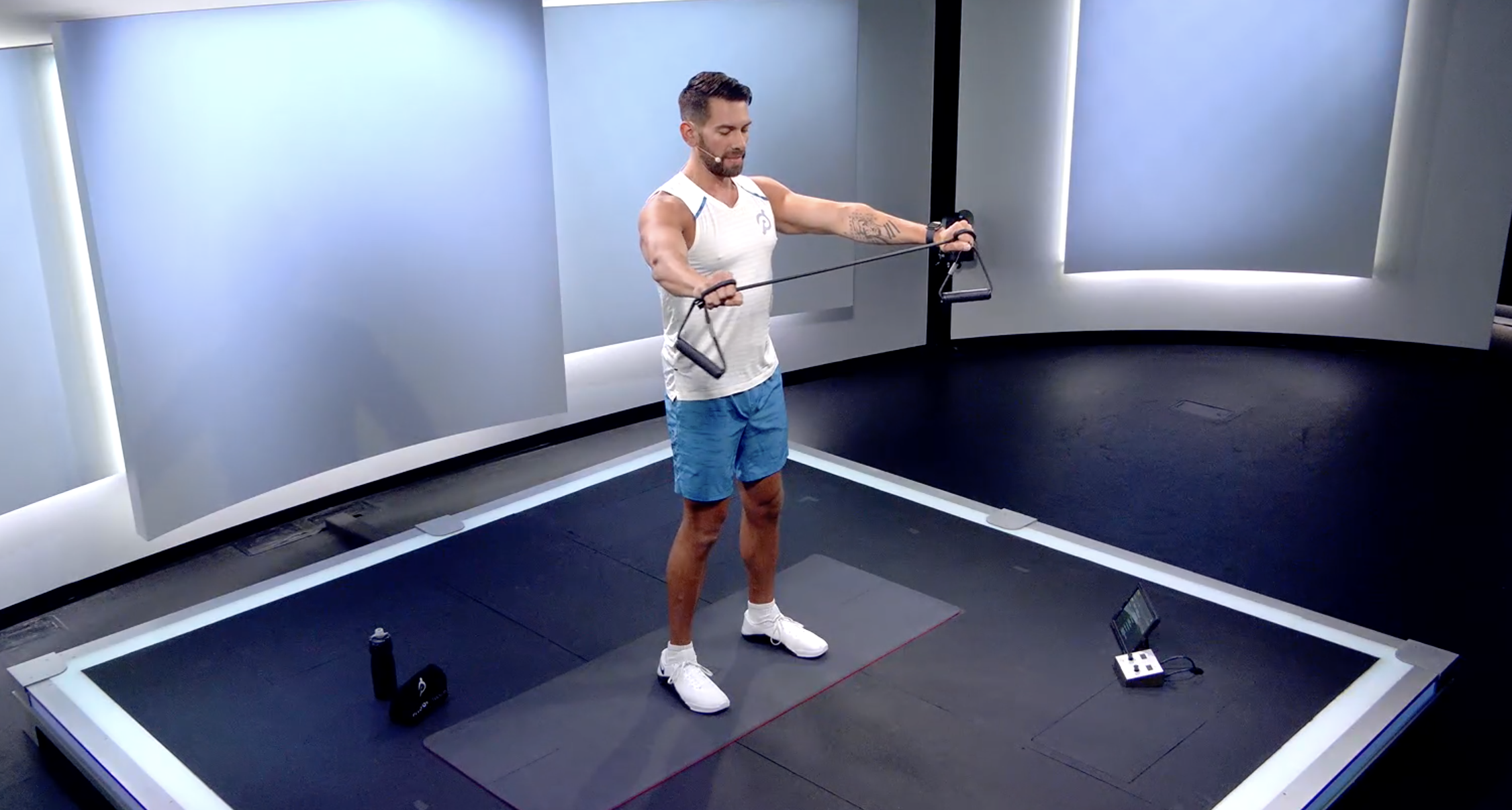 Peloton Instructor Matty Maggiacomo demonstrates upper body resistance band workout move
