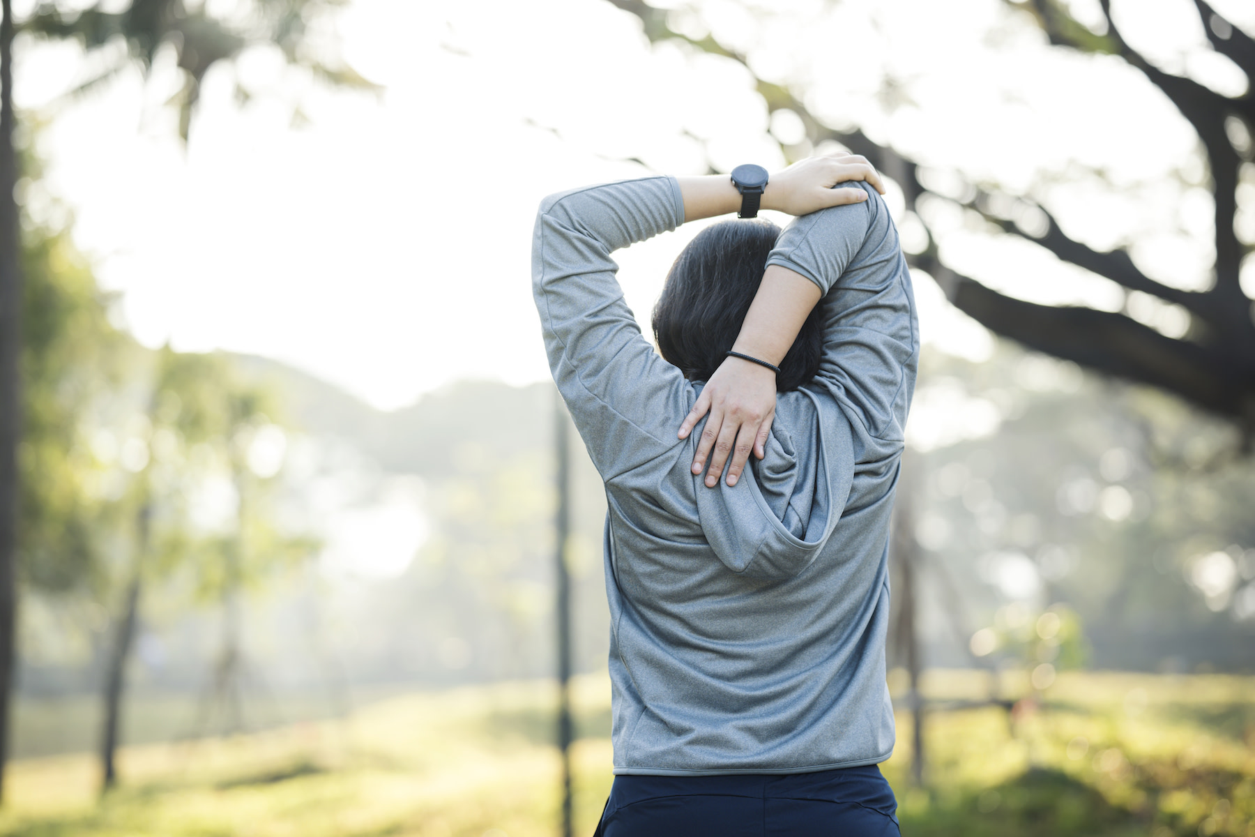 Woman does an overhead tricep stretch, a shoulder mobility exercise