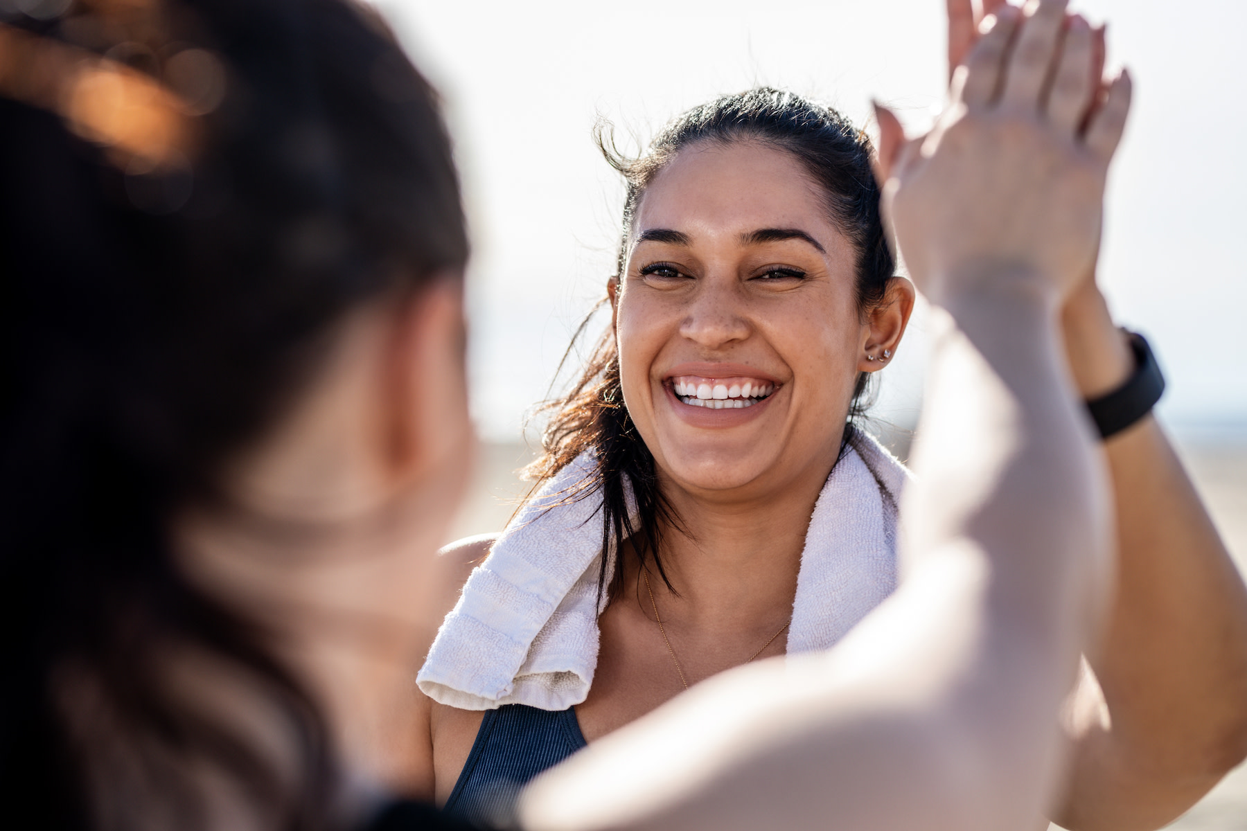 Wellness Trends: A young woman happily high-fiving her friend after a workout.