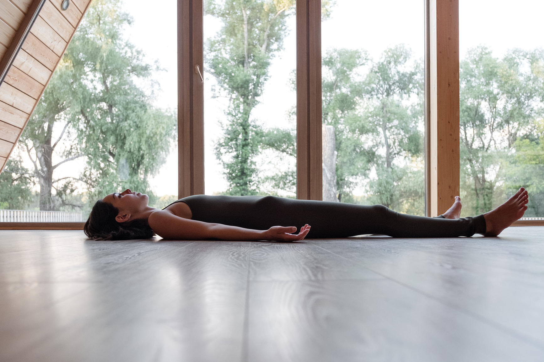 Side view of woman on the ground in Savasana (corpse pose)