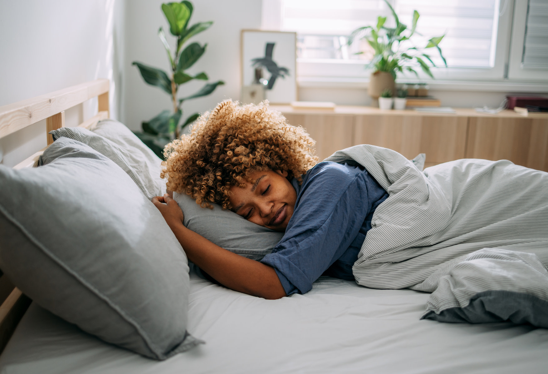 A woman taking a power nap in bed.