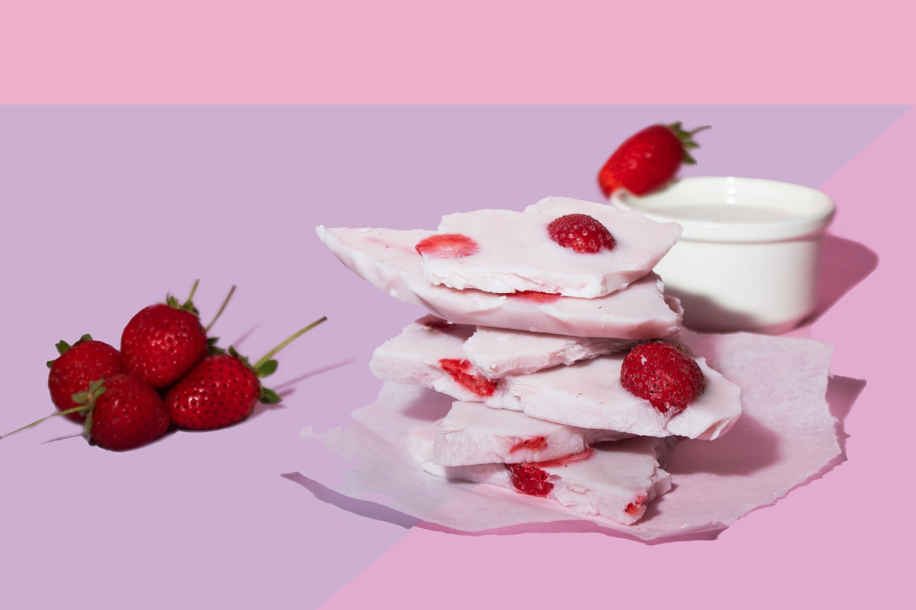 A plate of frozen Greek yogurt bark (a high-protein snack) topped with strawberries.