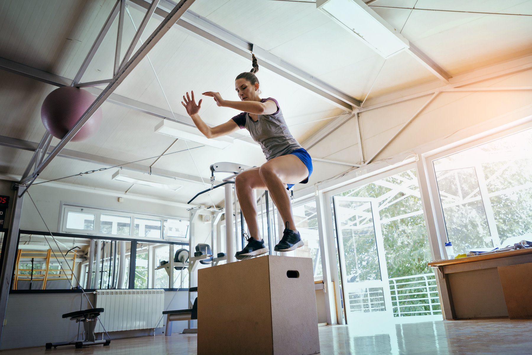 Woman does a box jump, one of the best plyometric exercises