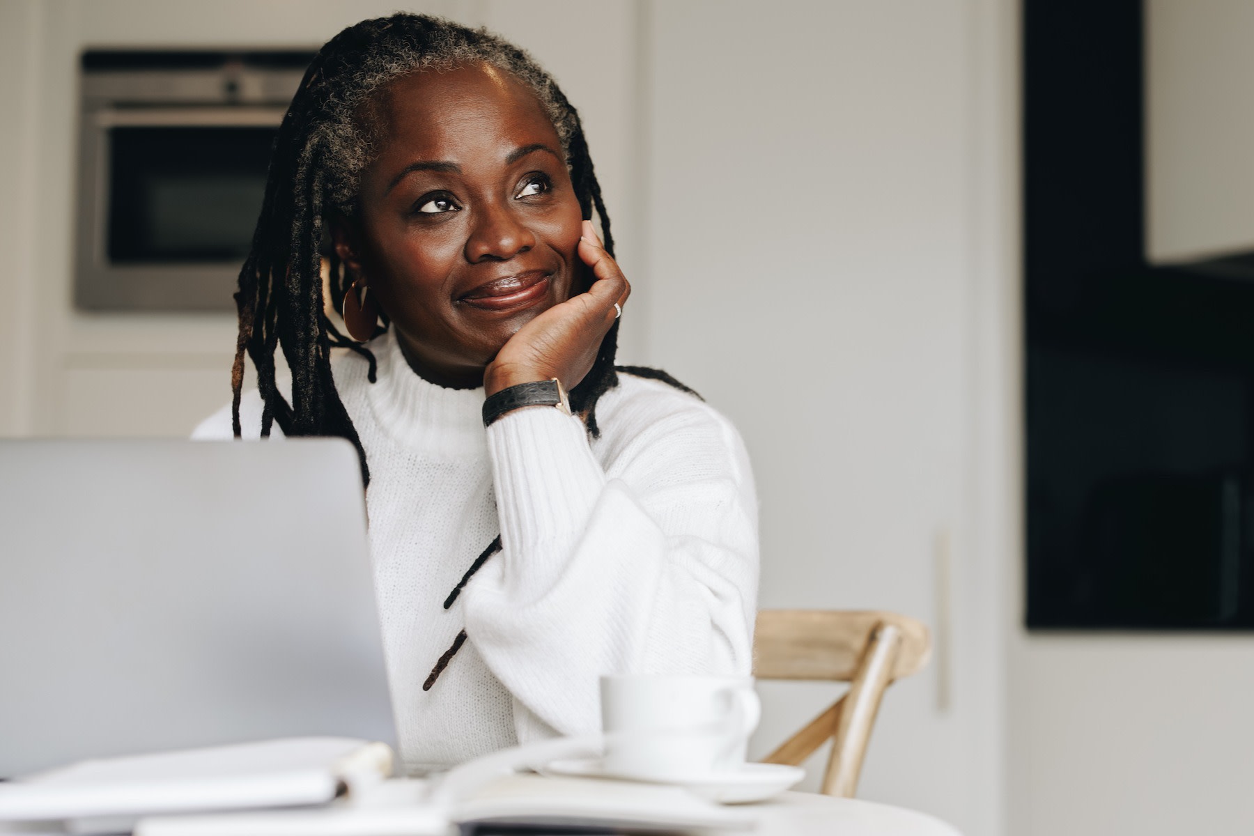 How to Change Your Mindset: A woman thoughtfully thinking at her computer.